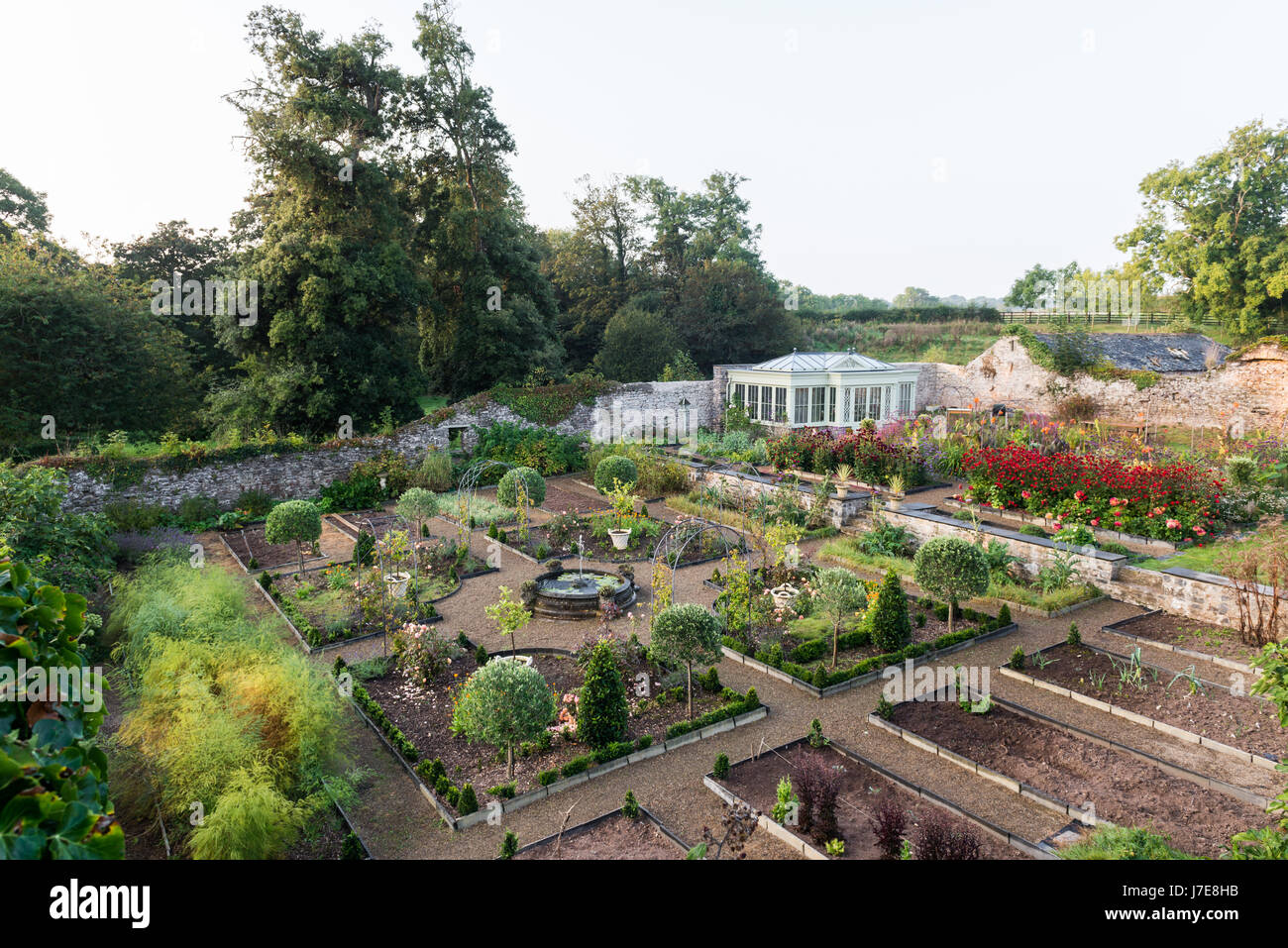 Giardino murato con summerhouse da David Salisbury. La neat refilato letti del potagers terrazza inferiore complementate da topiaria da, wirework e archi Foto Stock