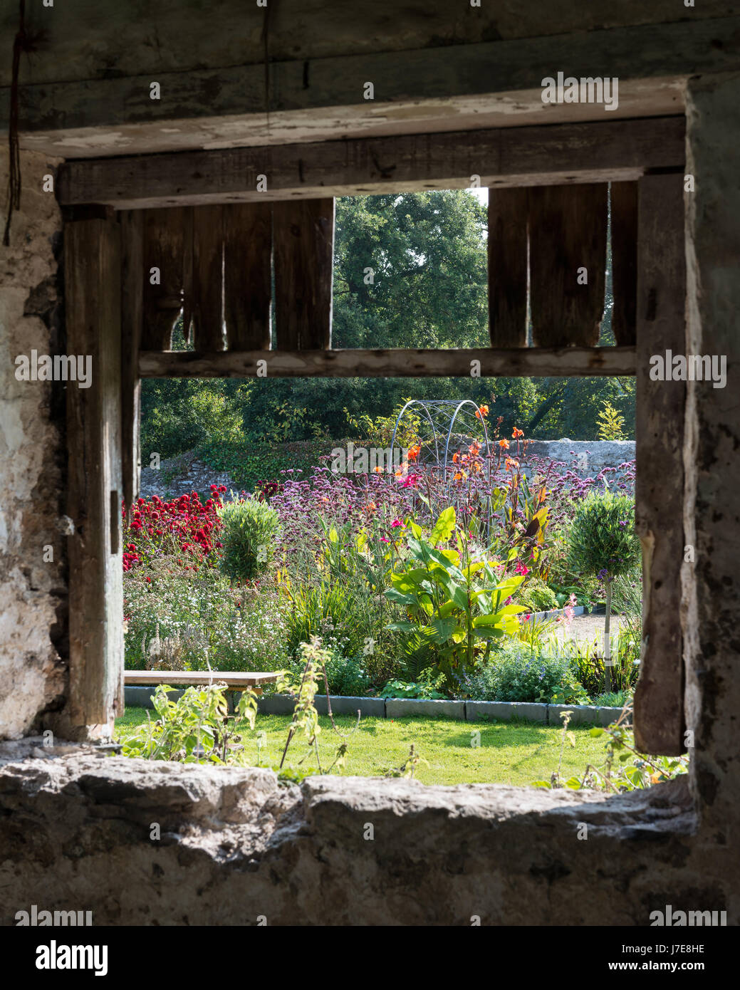 Vista attraverso il fienile rustico finestra per walled garden Foto Stock
