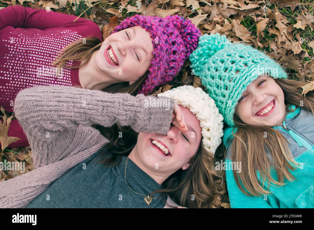 Le tre ragazze ridere di indossare cappelli Foto Stock