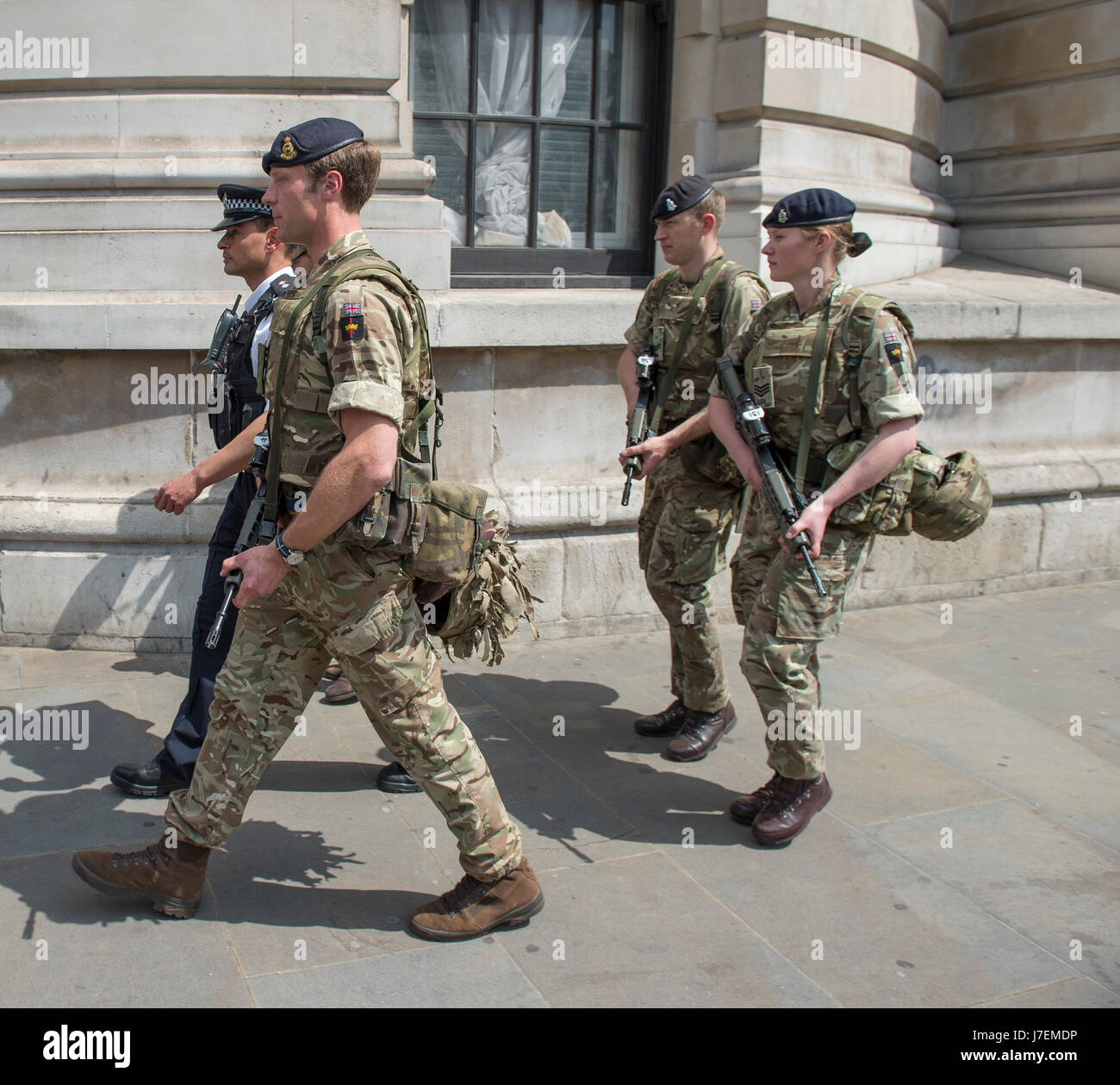 Whitehall, Londra UK. Xxiv Maggio, 2017. Truppe armate, accompagnato da un funzionario di polizia, di pattuglia in Whitehall voce verso Trafalgar Square. Le truppe sono state spostate in diverse posizioni in seguito alla Manchester terrore sdegno. Credito: Malcolm Park editoriale/Alamy Live News Foto Stock