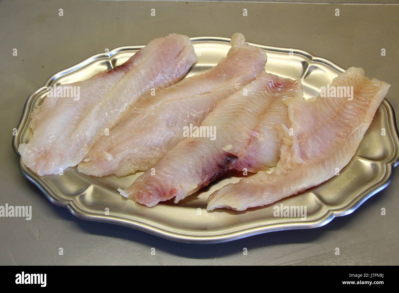 Materie di filetto di pesce su un piatto in peltro Foto Stock