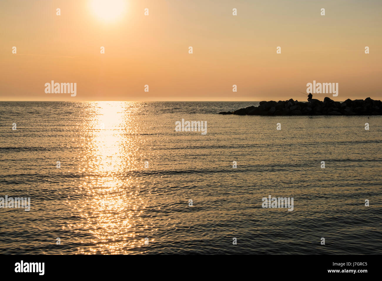 Tramonto sul mare a Ahrenshoop uomo pesca marittima Rocks off, Meclenburgo-Pomerania Occidentale, Germania Foto Stock