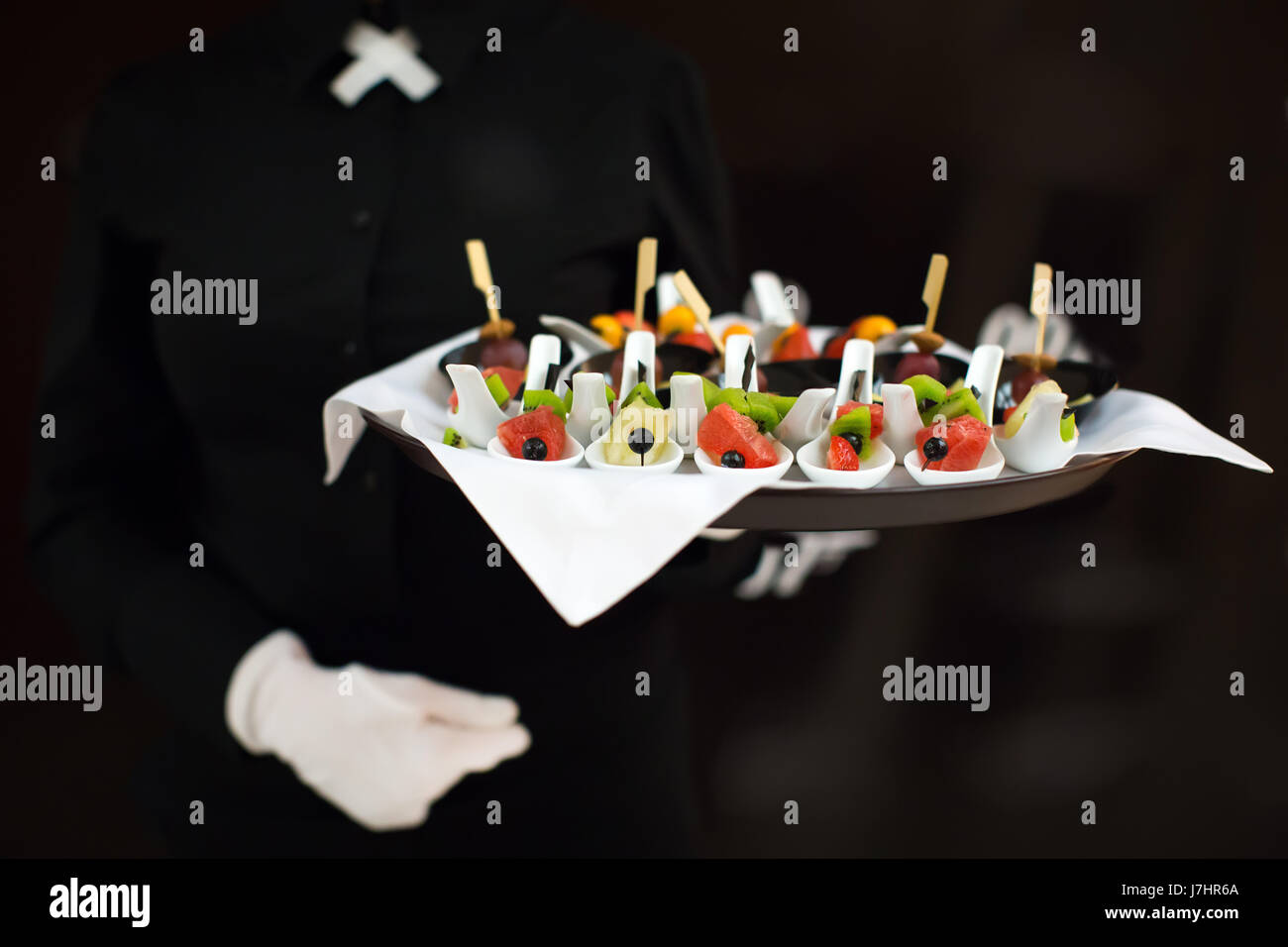 Un cameriere con un vassoio di snack a un banchetto Foto Stock