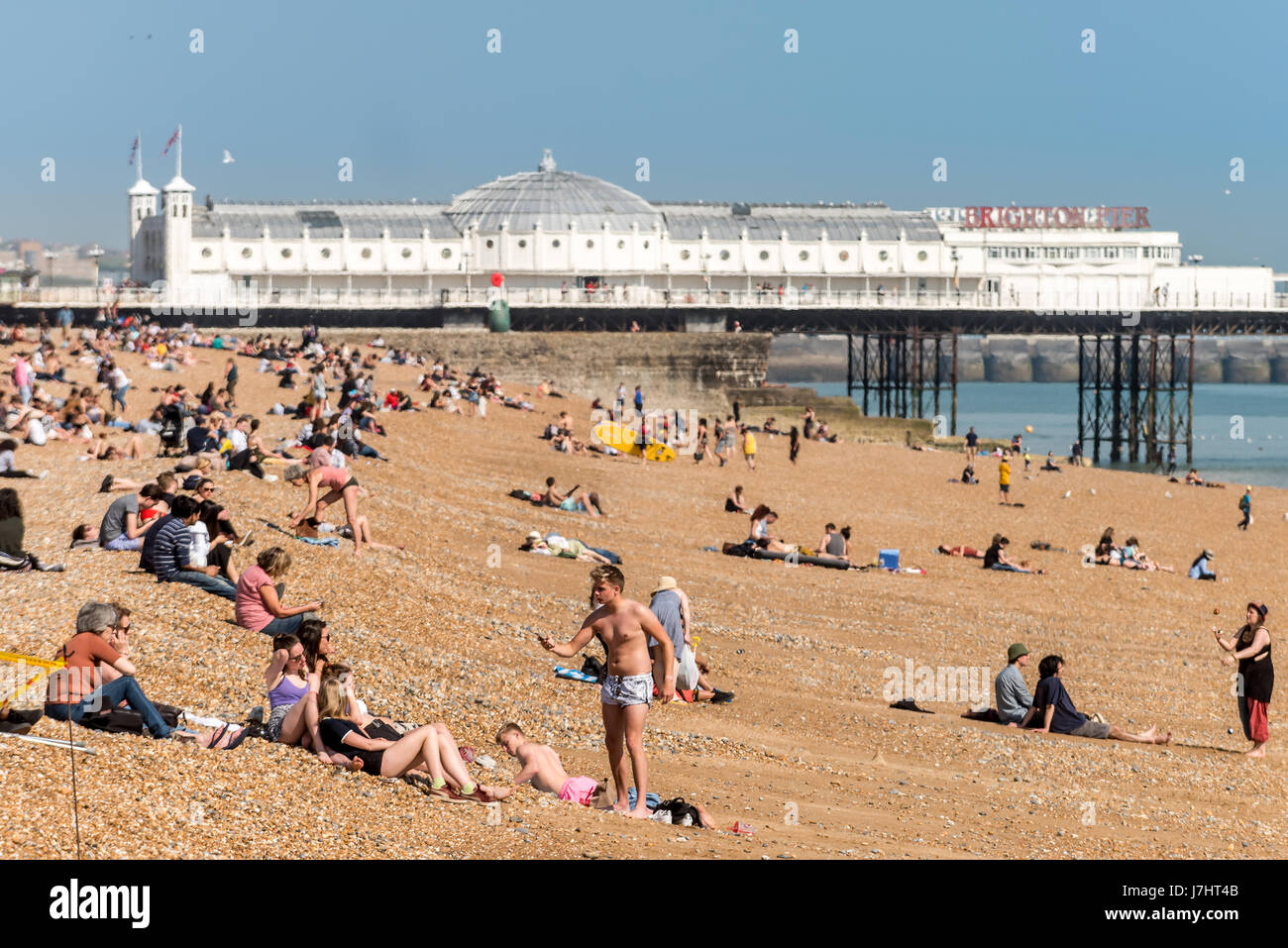 Escursionisti locali e godetevi la torrida condizioni sulla spiaggia di Brighton questo pomeriggio Foto Stock