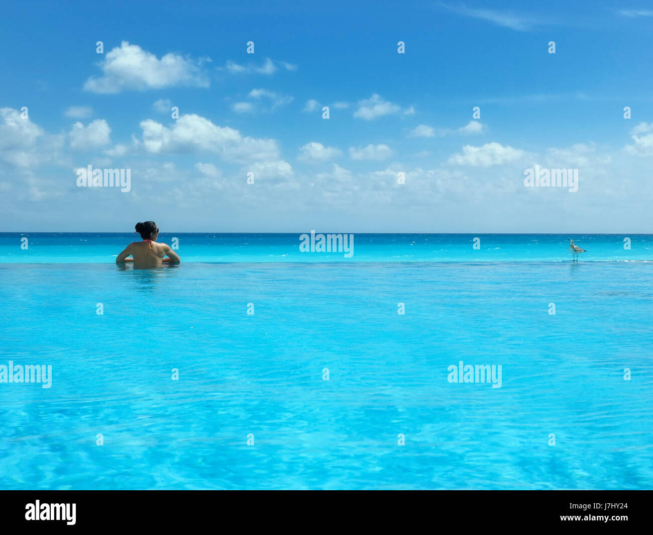 Donna in piscina con vista sul mare Foto Stock