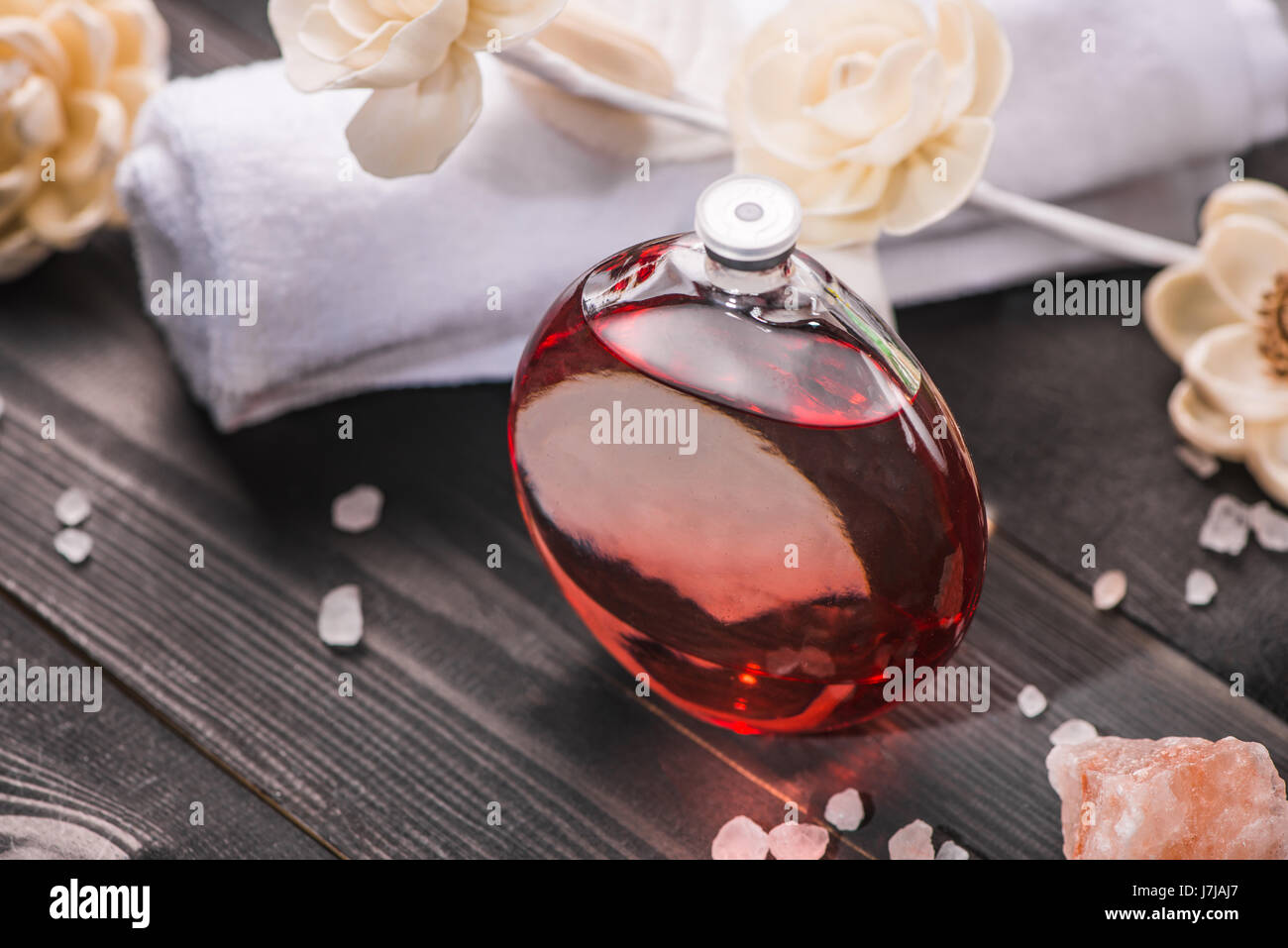 Spa decorazione. Bottiglia di olio essenziale e progetto di fiori. Foto Stock