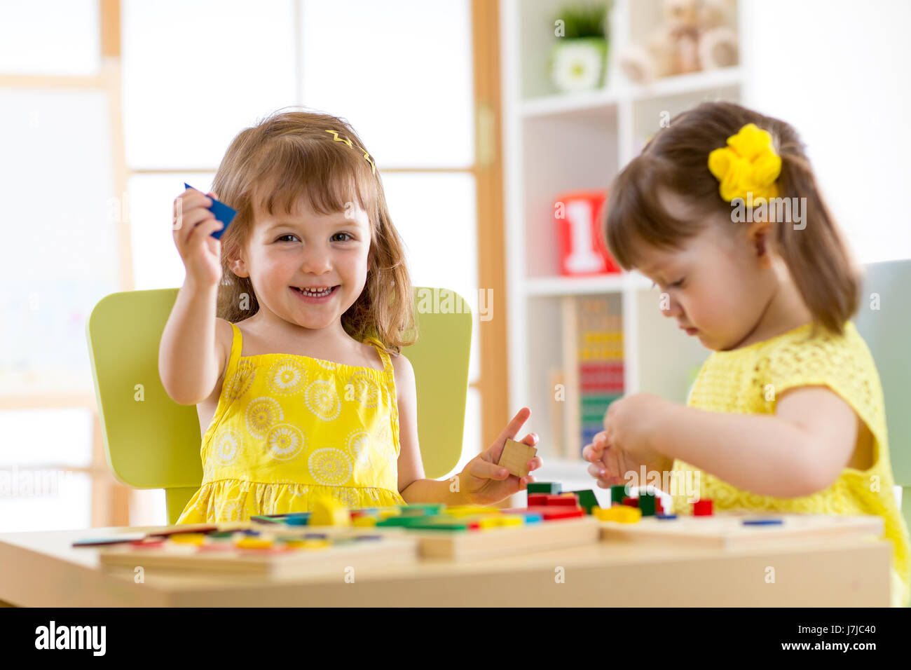 Bambini che giocano con i giocattoli di sviluppo a casa o asilo nido o playschool Foto Stock