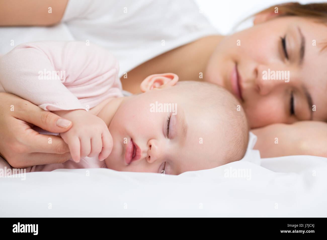 Giovane madre e il suo bambino, dormire nel letto Foto Stock