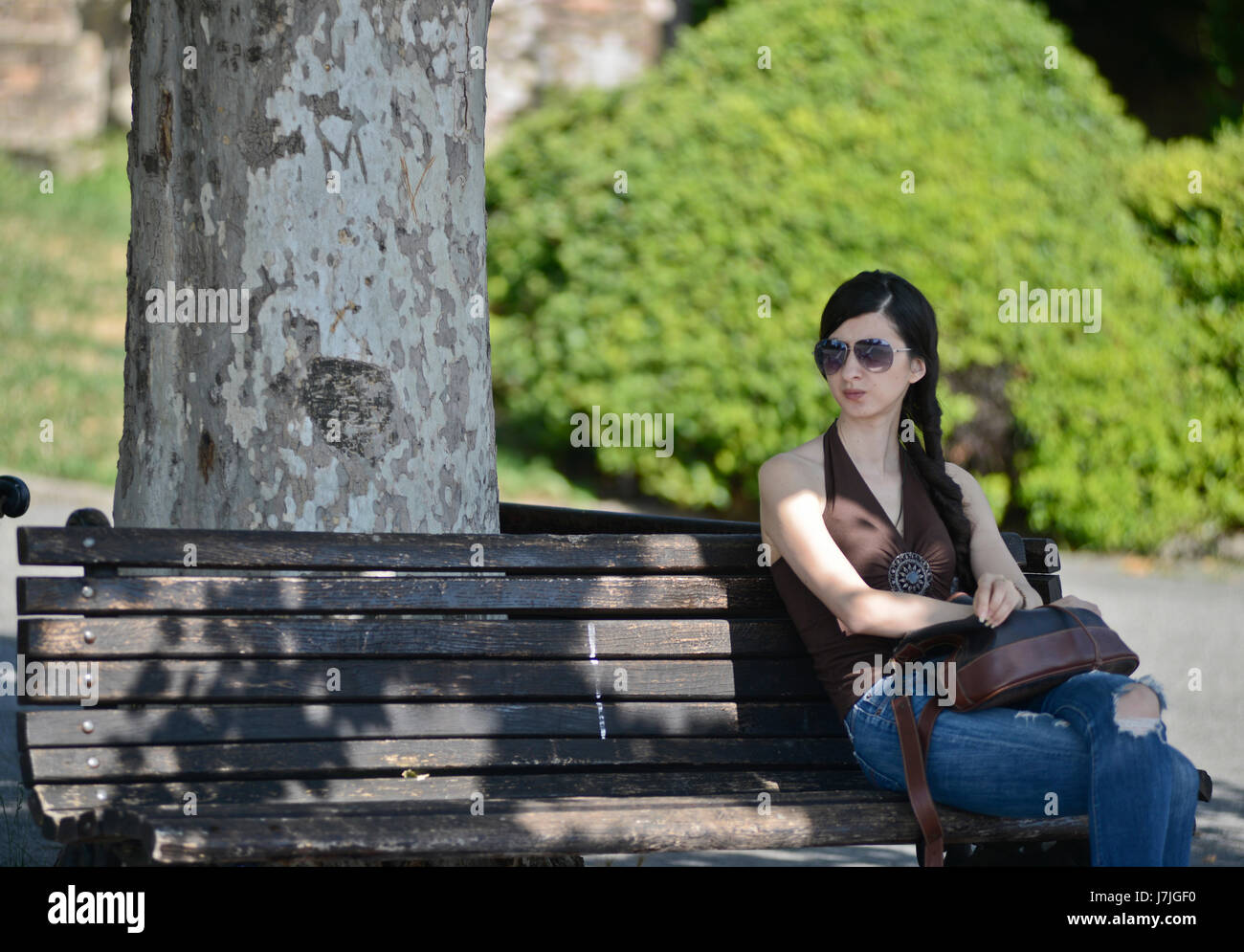 Ragazza brunetta in attesa in una panchina nella fortezza di Kalemegdan, Belgrado (Serbia) Foto Stock