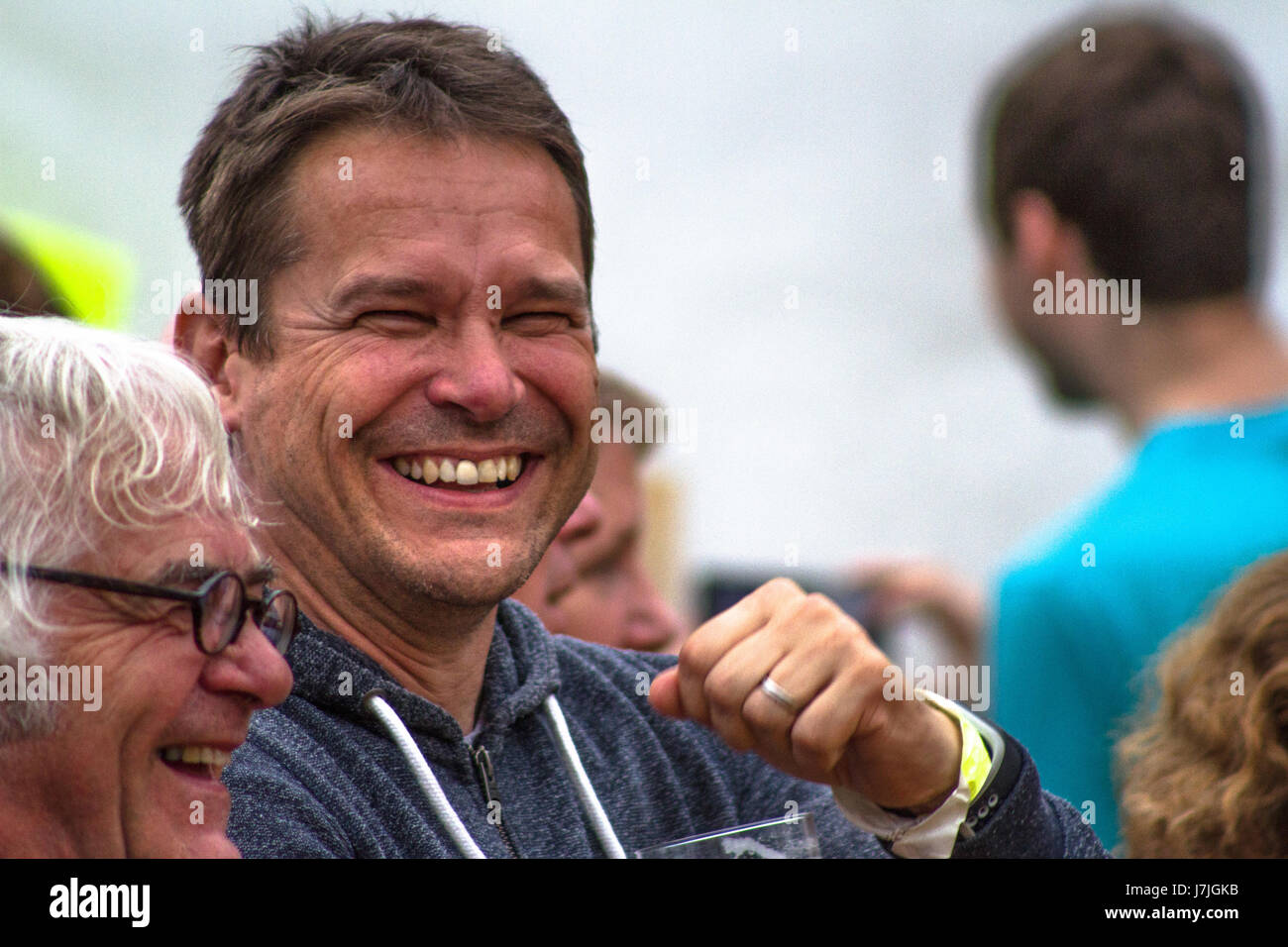 Un uomo di mezza età ride verso la telecamera mentre si parla al castello di Carrock, Cumbria, Regno Unito. Foto Stock