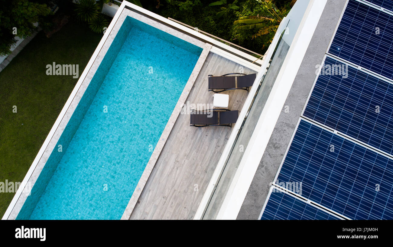 Vista superiore della piscina esterna e pannelli solari sul tetto della villa Foto Stock
