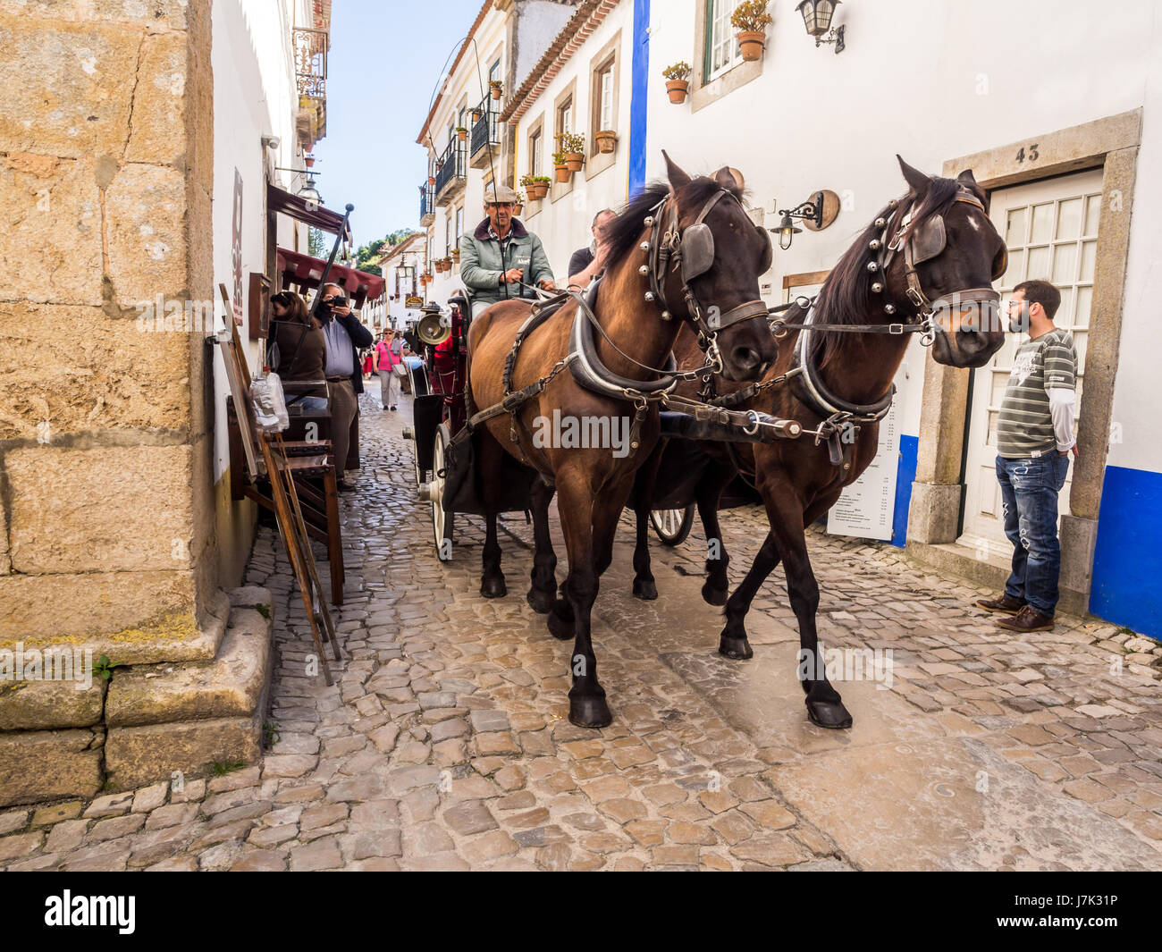 OBIDOS, Portogallo - 03 Aprile 2017: la gente di equitazione a cavallo carrello sulla strada principale di Obidos on April 03, 2017. Foto Stock