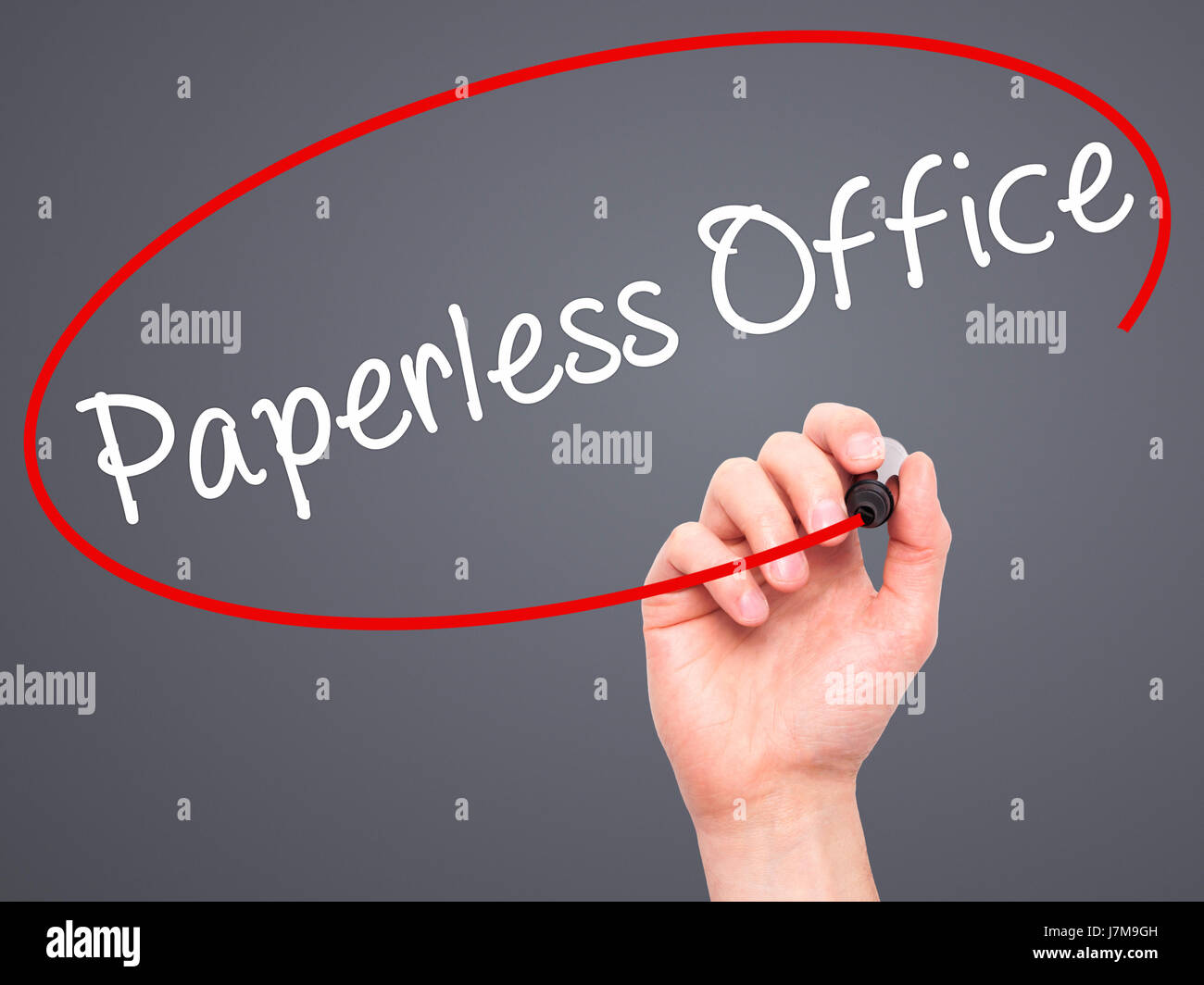 Man mano che scrive paperless office con un pennarello nero su schermo visivo. Isolato su grigio. Business, tecnologia internet concetto. Stock Photo Foto Stock