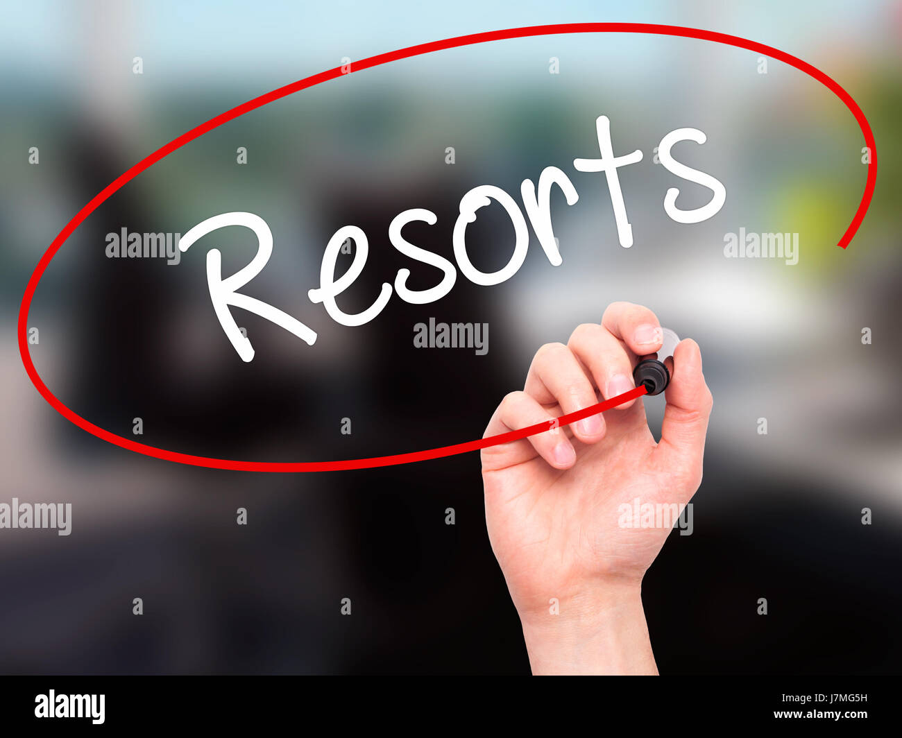 Man mano che scrive Resorts con pennarello nero su schermo visivo. Isolato su sfondo. Business, tecnologia internet concetto. Stock Photo Foto Stock