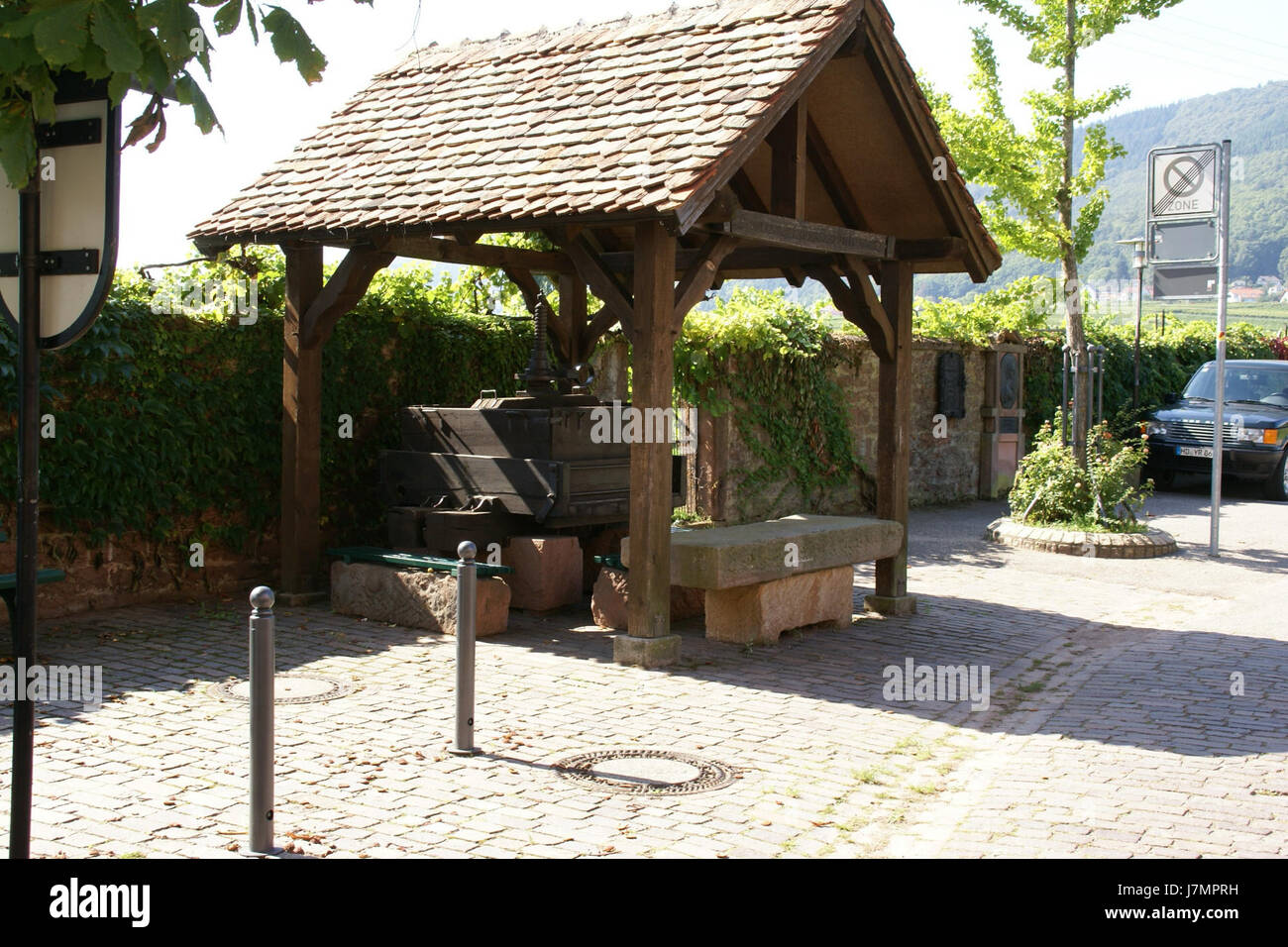 Questa immagine si riferisce a un frantoio a Rhodt, in Germania, lungo Theresienstrasse. Mette in evidenza un metodo storico di spremitura dell'uva, spesso utilizzato nella produzione del vino, che riflette il legame della regione con la viticoltura. Foto Stock