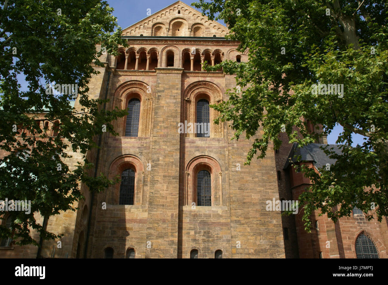 Questa fotografia cattura la vista laterale della cattedrale di Spira, un sito patrimonio dell'umanità dell'UNESCO. La cattedrale è un ottimo esempio di architettura romanica, che mette in mostra dettagli intricati e significato storico. Foto Stock