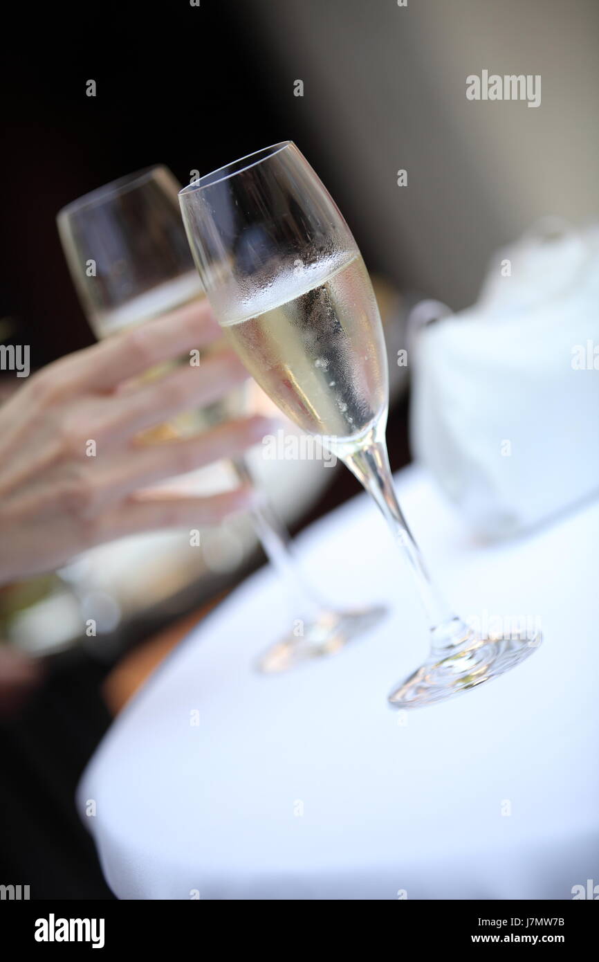 Calice di vetro tumbler mano celebrazione di partito cheers champagne bicchiere di prosecco Foto Stock