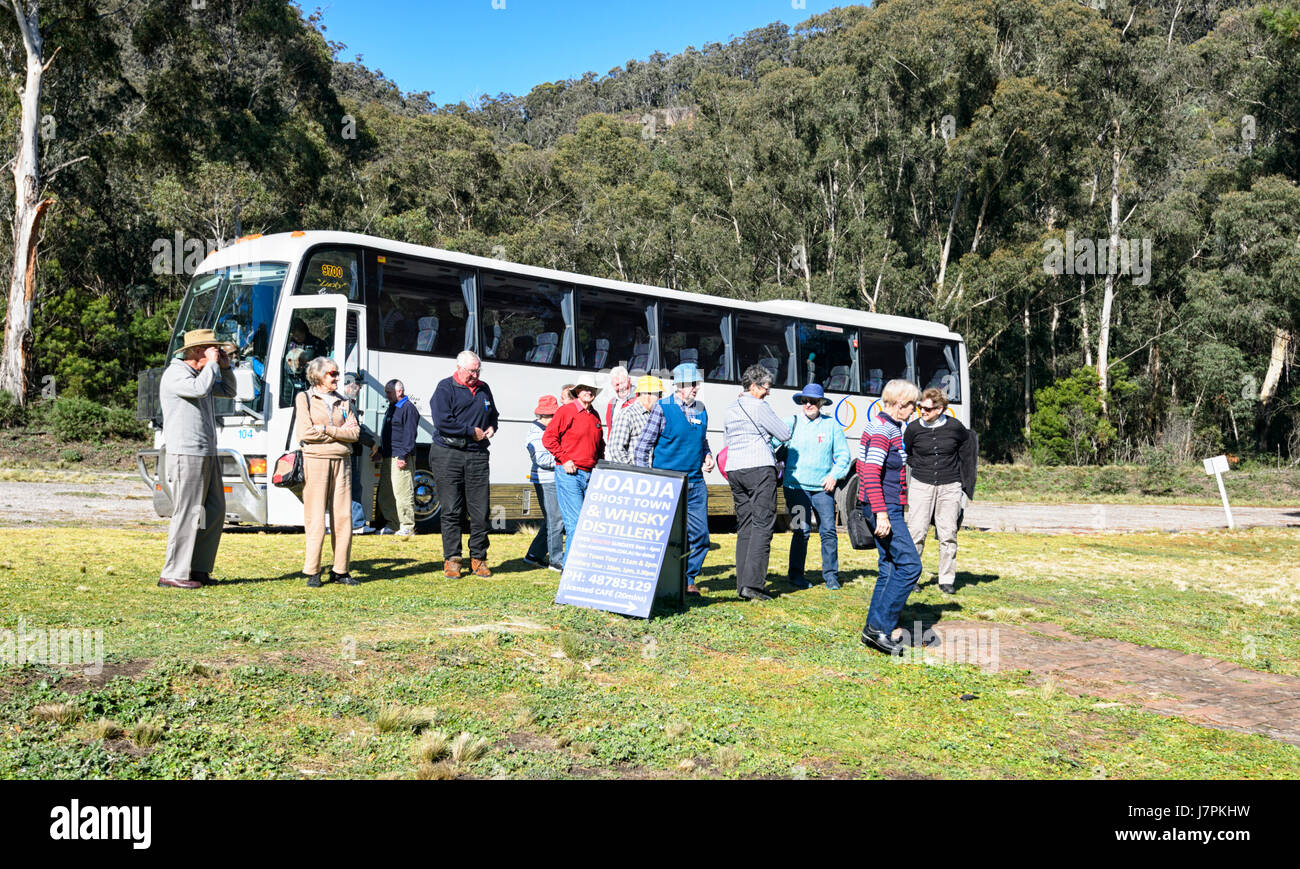 Gruppo di persone anziane scendere un pullman per visitare la Joadja città fantasma e distilleria Joadja, Southern Highlands, Nuovo Galles del Sud, NSW, Australia Foto Stock