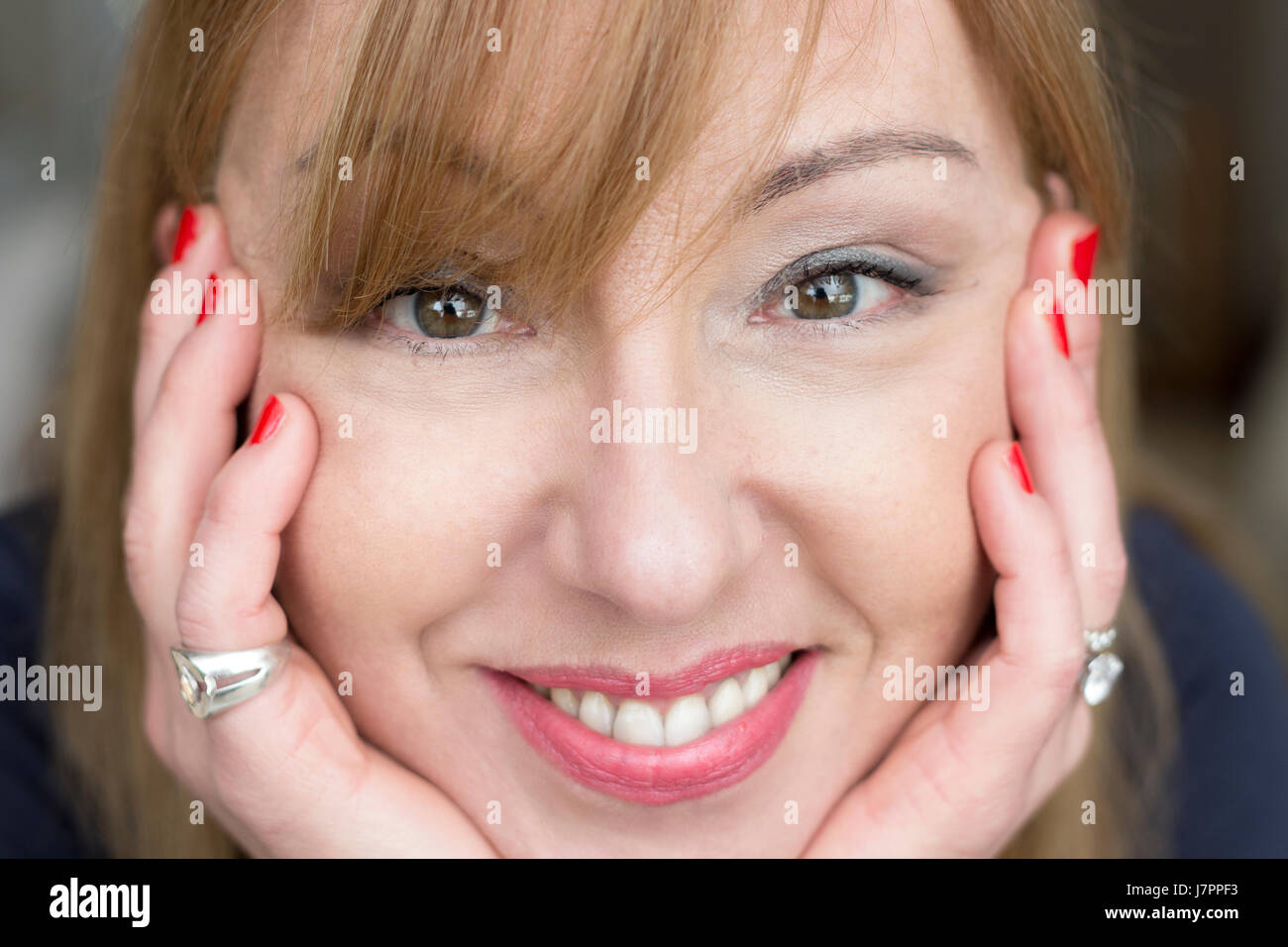 Ritratto di una donna matura, 45 anni, closeup, guardando la telecamera, sorridente, home background. Foto Stock