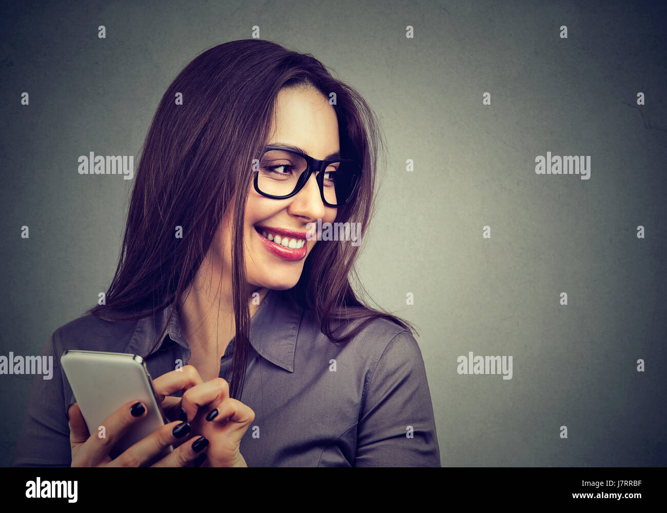 Bella donna utilizzando smart phone cercando via ridendo Foto Stock