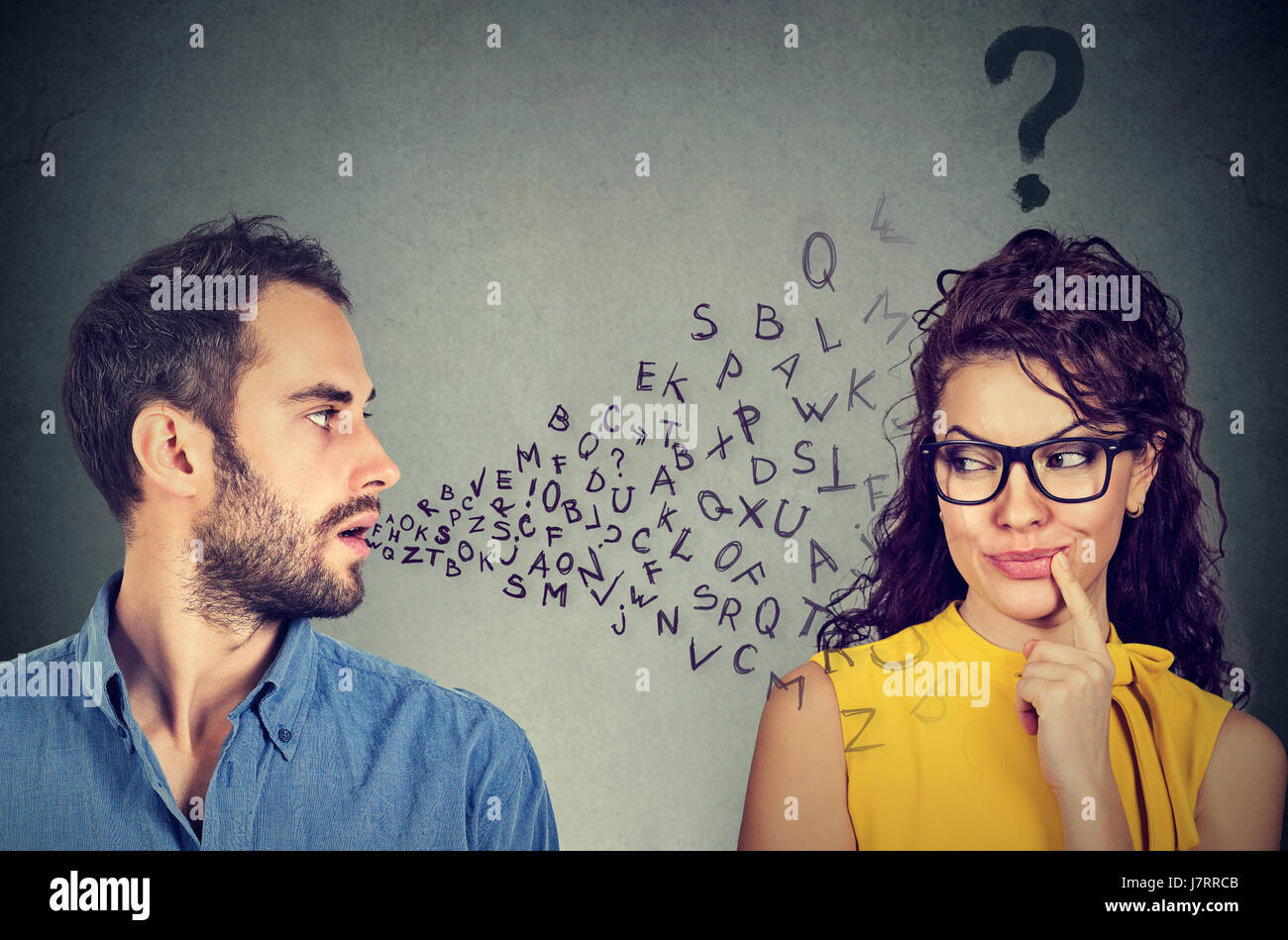 Barriera linguistica concetto. Uomo bello parlare a un attraente giovane donna con punto interrogativo Foto Stock