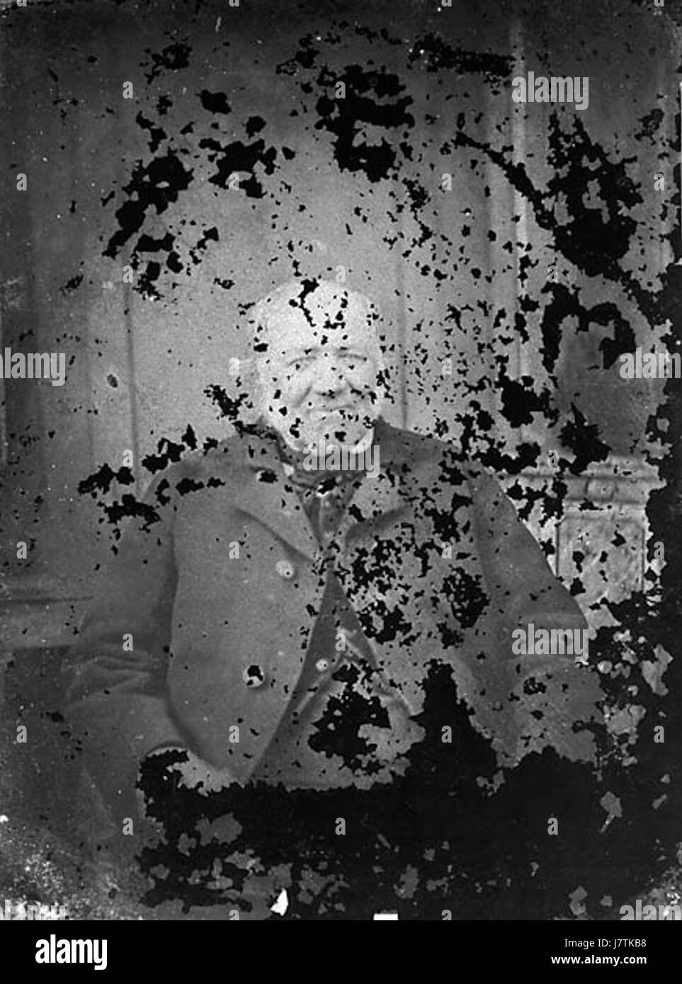 Questa immagine raffigura un uomo anziano seduto, possibilmente in una posa riflessiva o contemplativa. La foto cattura un momento di riflessione tranquilla e il passare del tempo. Foto Stock