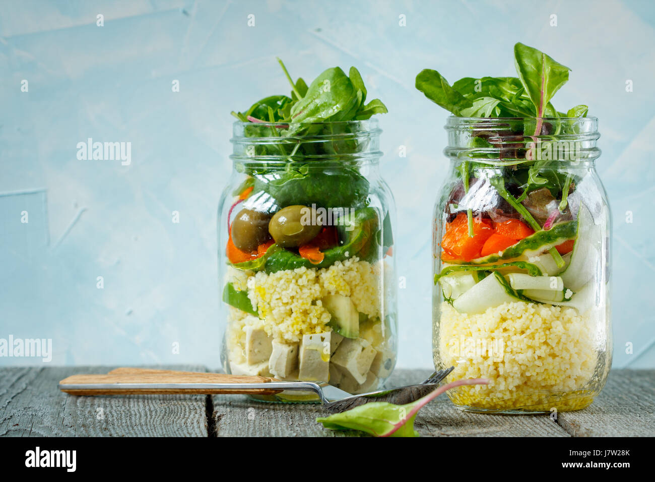 Colorato con insalata di cuscus, tofu e verdure in un vaso. Amore per un sano cibo vegan concept Foto Stock