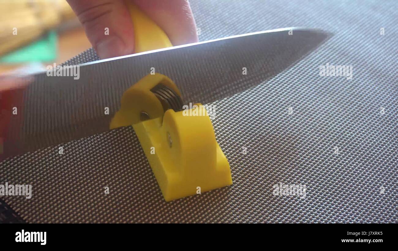 Coltello e temperino per un coltello nelle mani dell'uomo. Manuale di affilatura coltelli Foto Stock