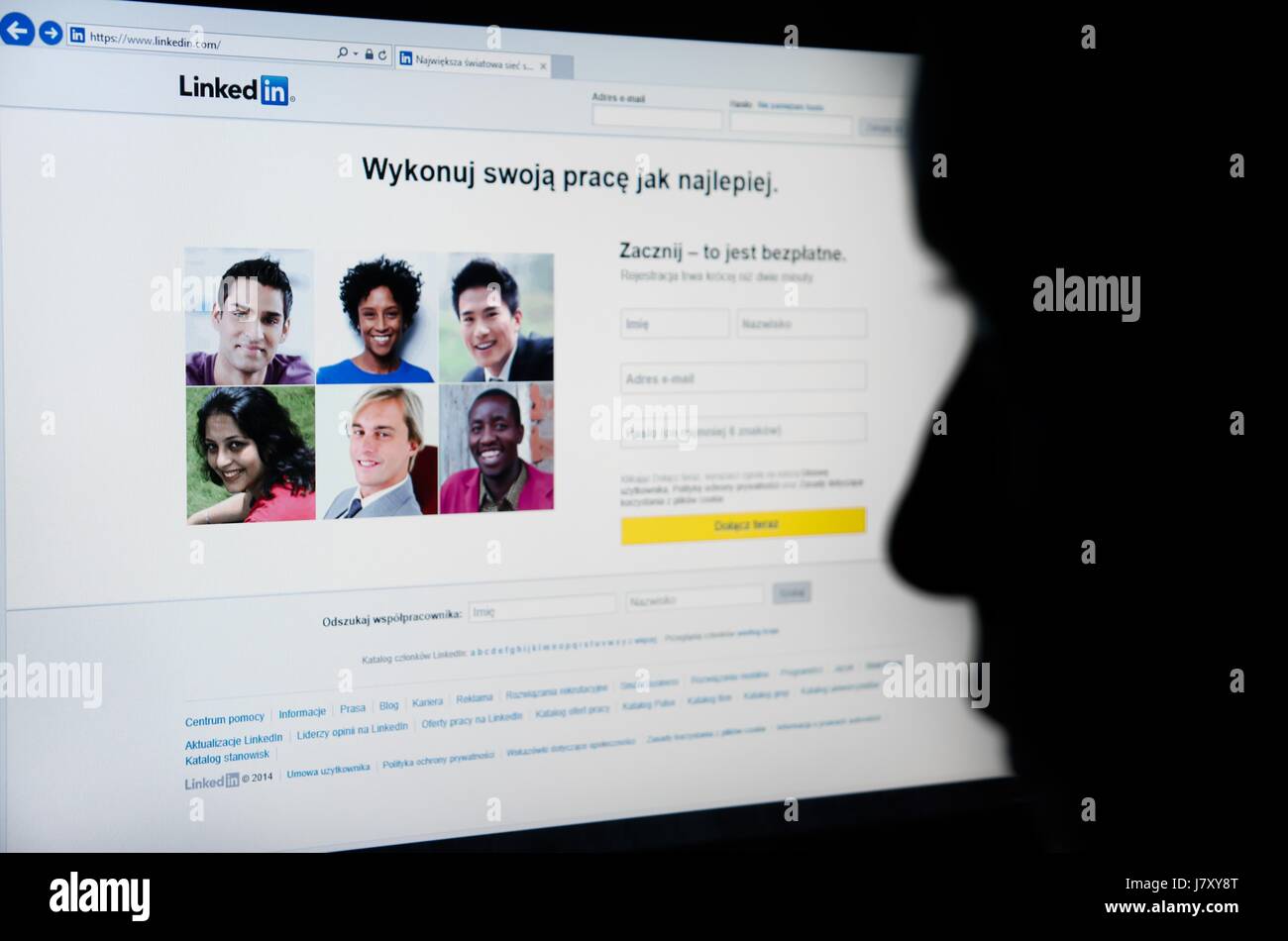 Faccia guardando Linkedin.com homepage sullo schermo - business-oriented di servizio di social network Foto Stock