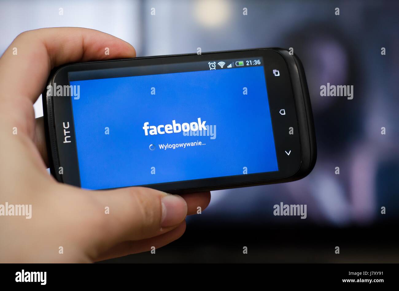 Mano azienda smartphone con il social network Facebook mobile app Foto Stock