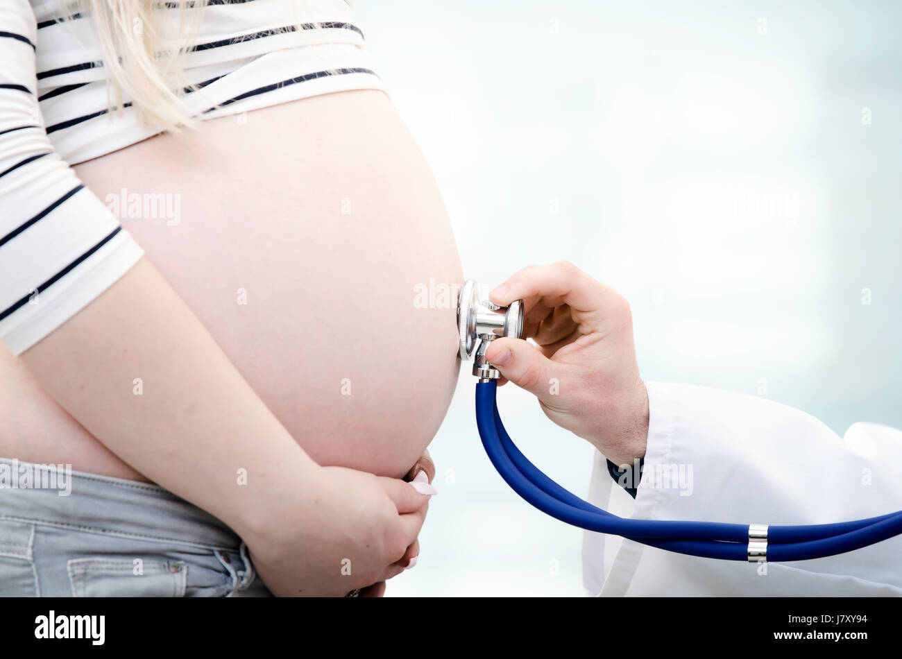 Medico utilizzando uno stetoscopio esaminando la donna incinta gravidanza medico Donna salute concetto Foto Stock