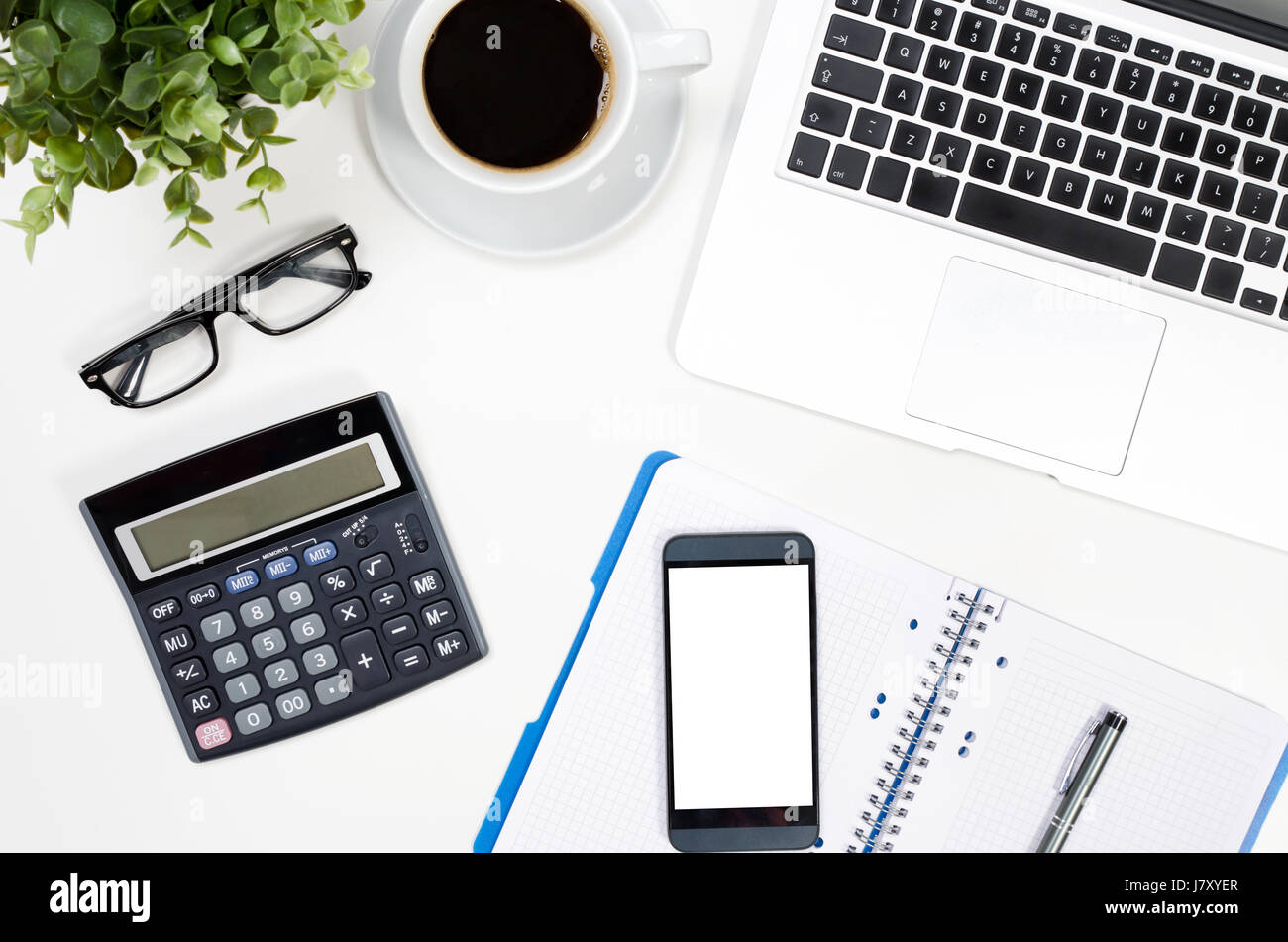 Ufficio tavolo scrivania con computer portatile, tazza di caffè e delle forniture di ufficio vista superiore Foto Stock