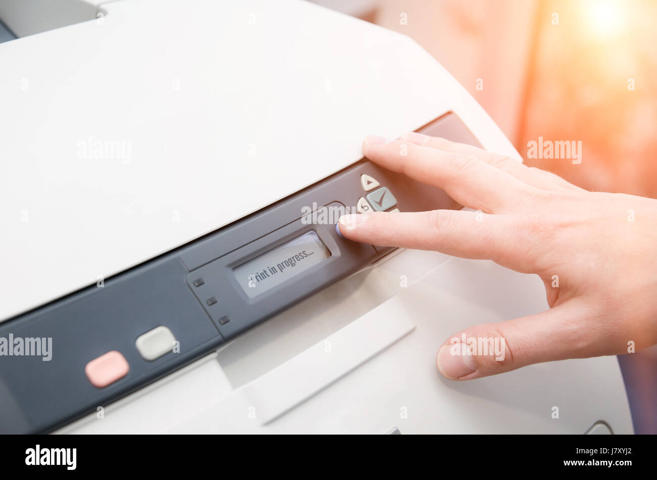 L'uomo tenendo premuto il dito sul pulsante di avvio della stampante laser Foto Stock