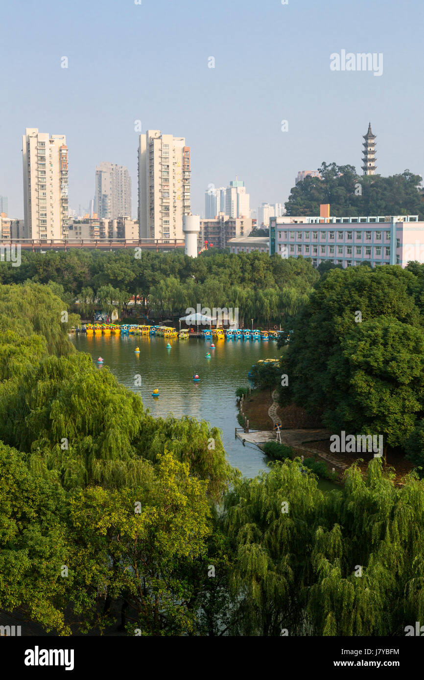 Wenzhou, Zhejiang, Cina. Edifici di appartamenti in background, le barche da diporto sul lago in primo piano. Foto Stock