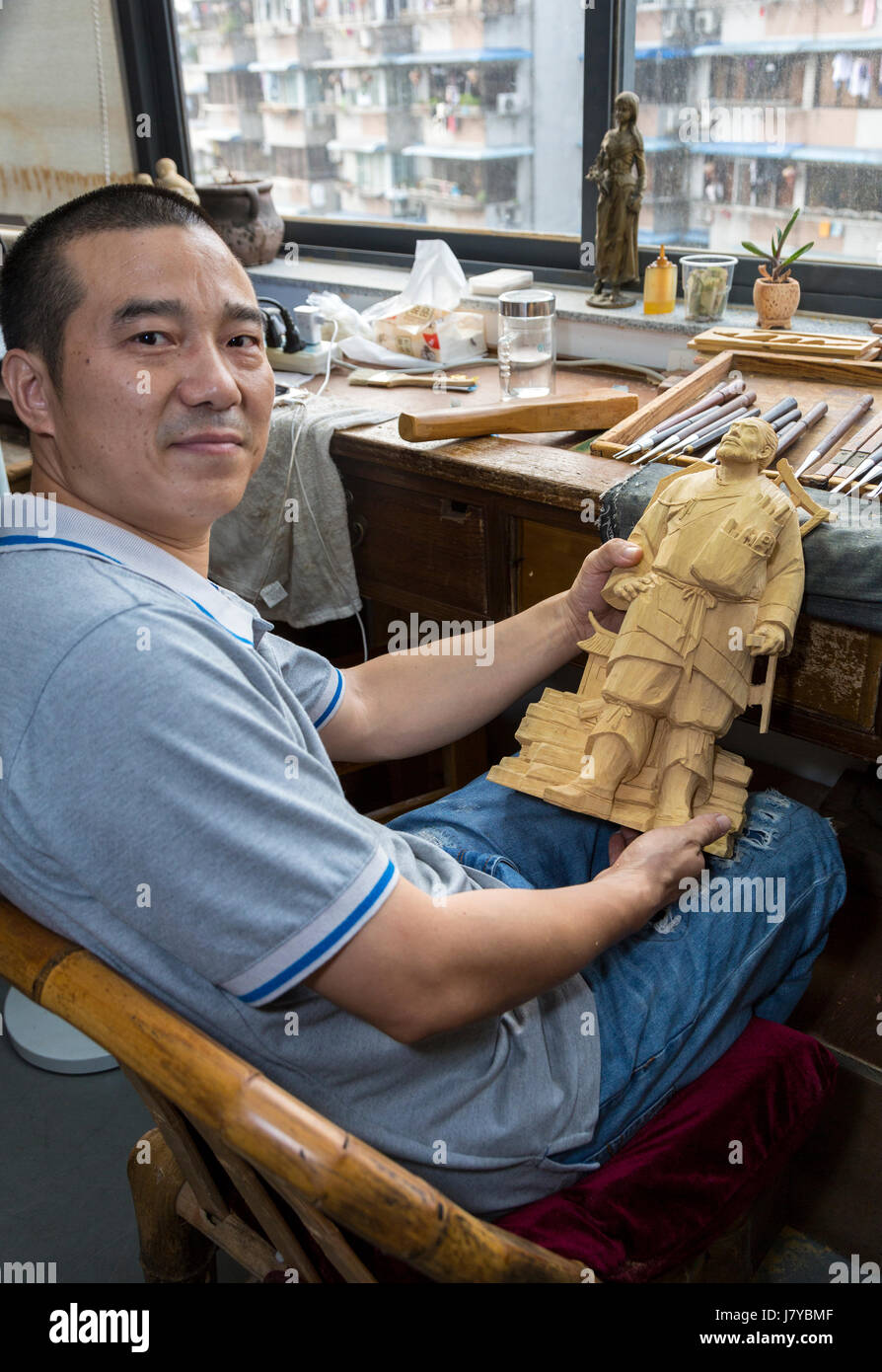 Wenzhou, Zhejiang, Cina. Artista Yung Huachun con la figura di Luo Bang, creatore di intaglio del legno di bosso, arti e mestieri Istituto di ricerca. Foto Stock