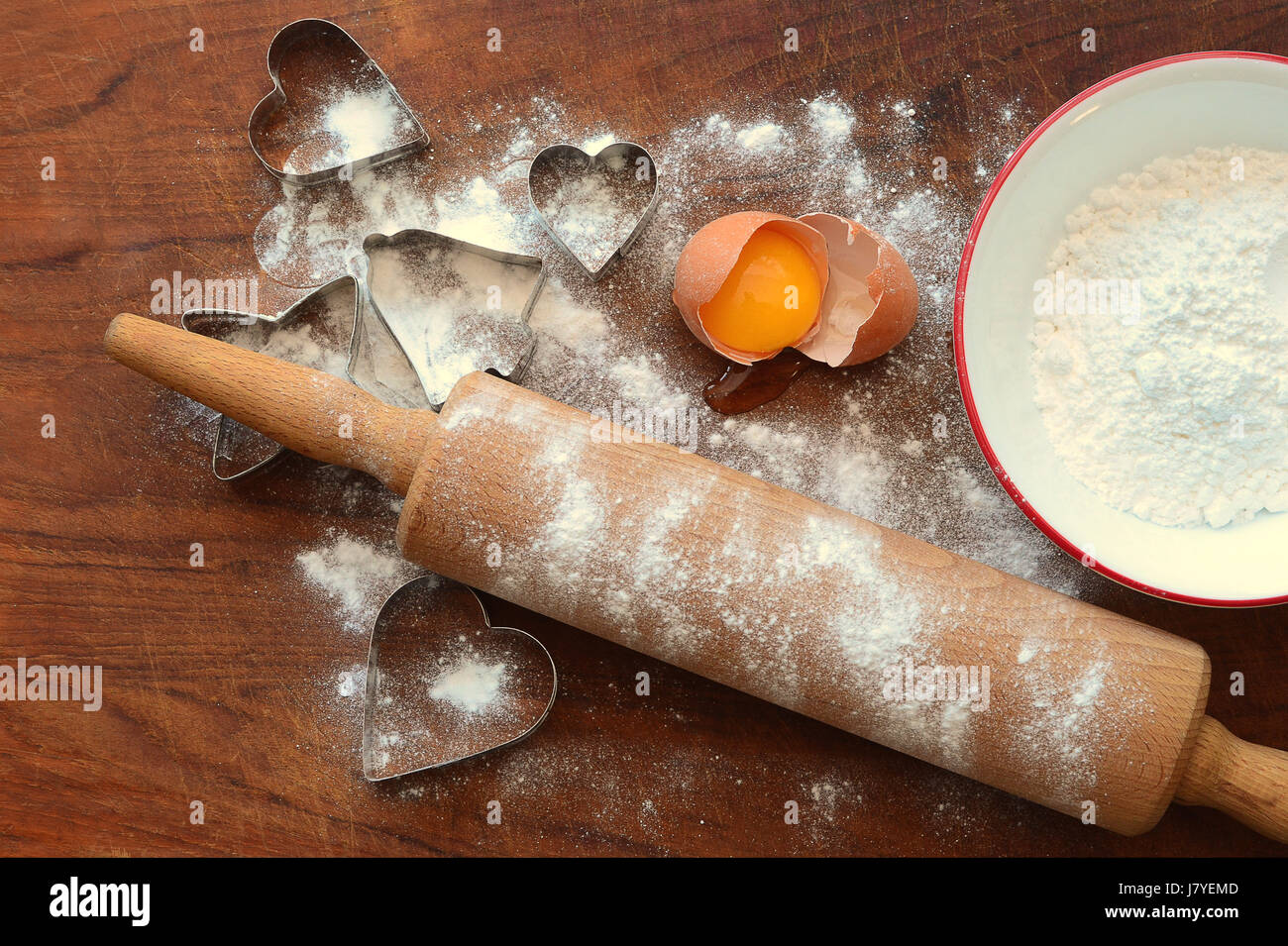 Legno di rotolamento con cottura ingredienti, farina, uova, cookie cutters sul pannello di legno Foto Stock
