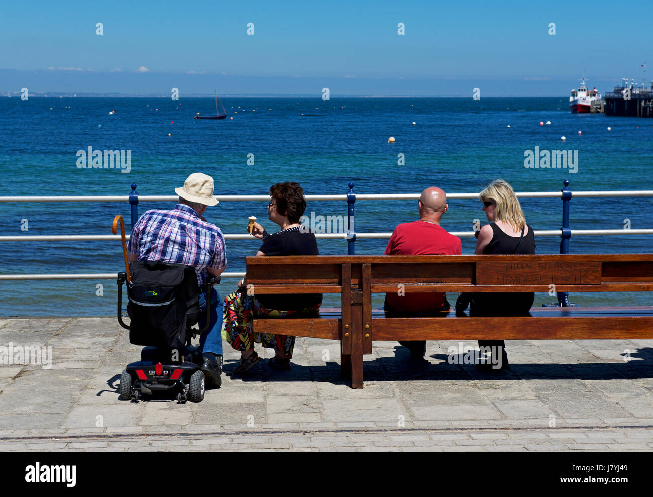 Due coppie relax su banco, Swanage Dorset, Regno Unito Inghilterra Foto Stock