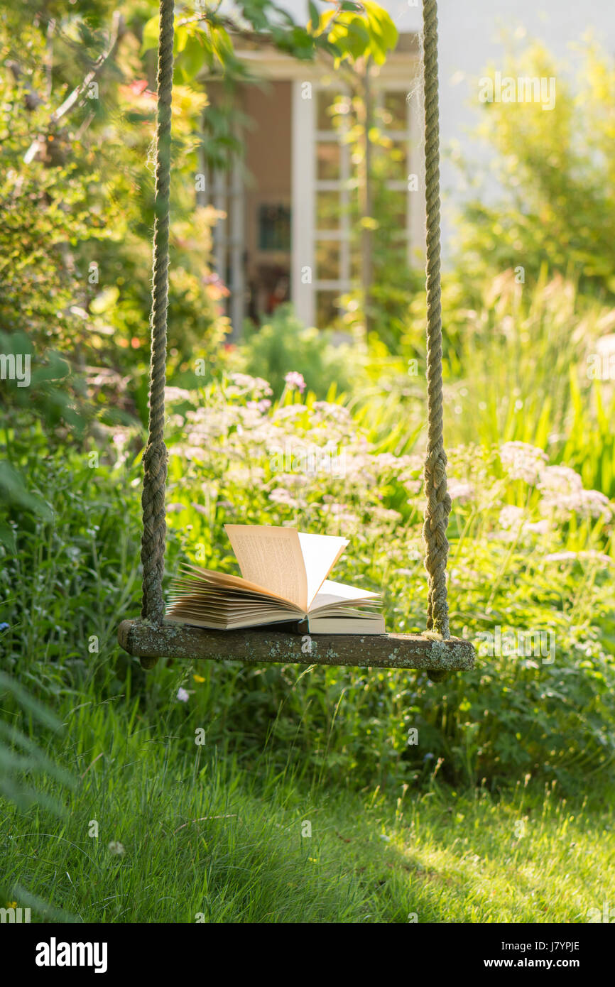 Libro aperto sul giardino swing in UK giardino sul retro Foto Stock