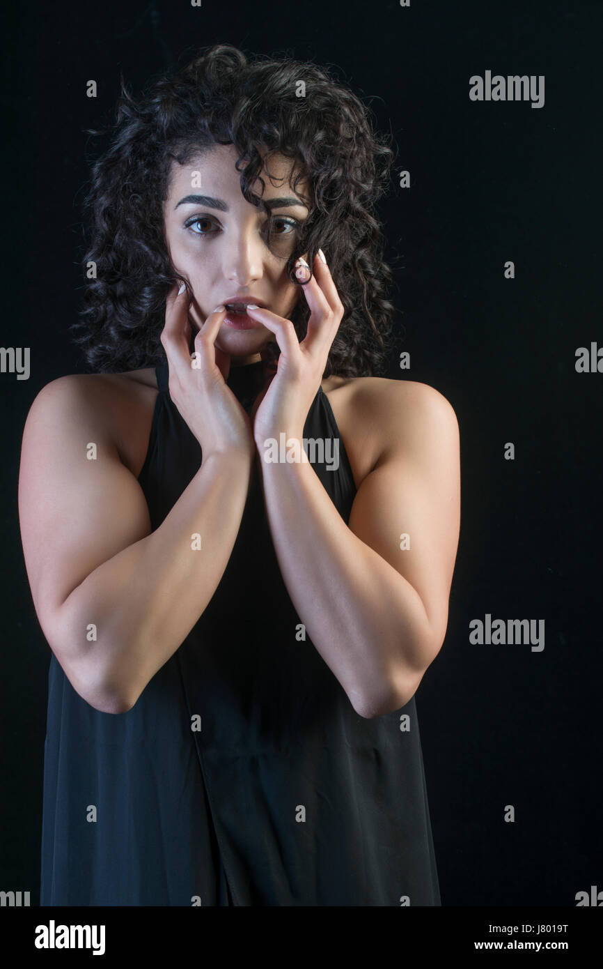 Spaventata giovane donna mani toccano la faccia Foto Stock