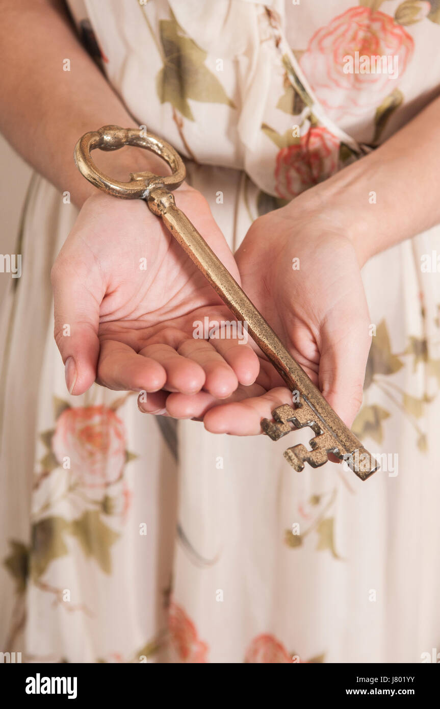 In prossimità di una giovane donna che mantiene una grande chiave di metallo Foto Stock