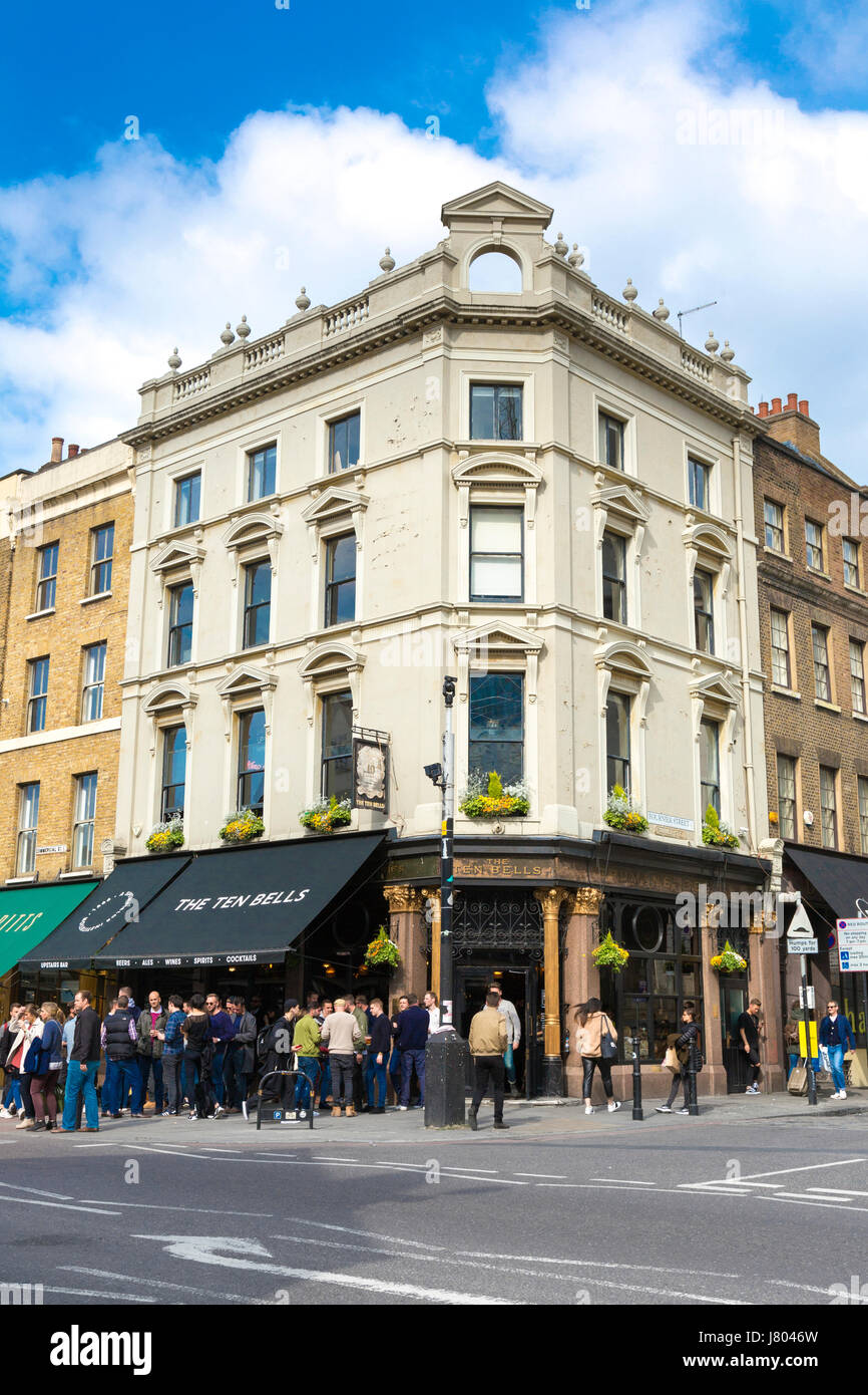 La folla di gente beve al di fuori dei dieci campane pub sulla strada commerciale in Spitalfileds, London, Regno Unito Foto Stock