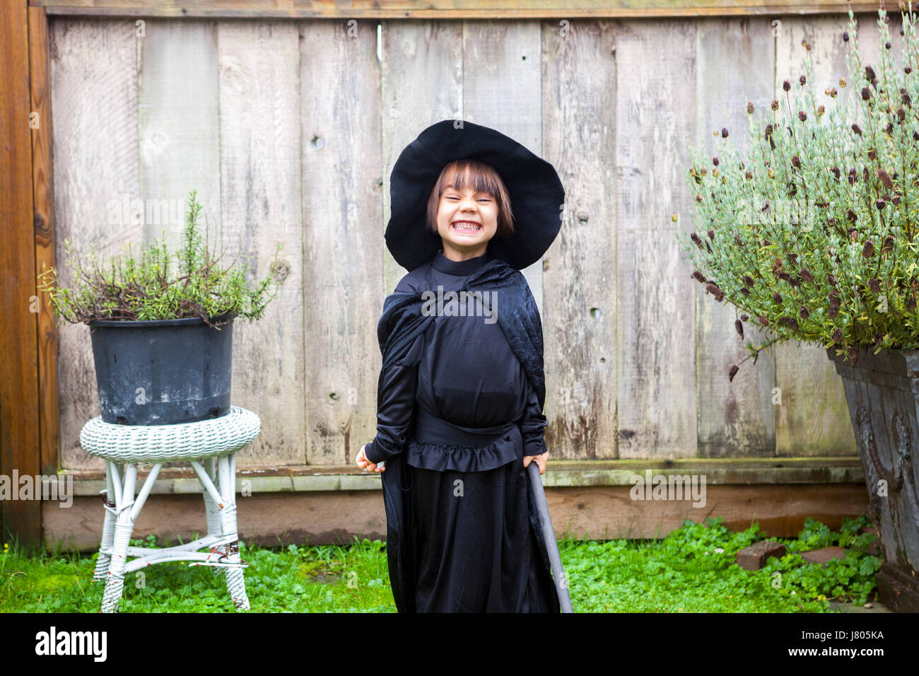 Ritratto ragazza entusiasta indossando il costume strega in giardino Foto Stock