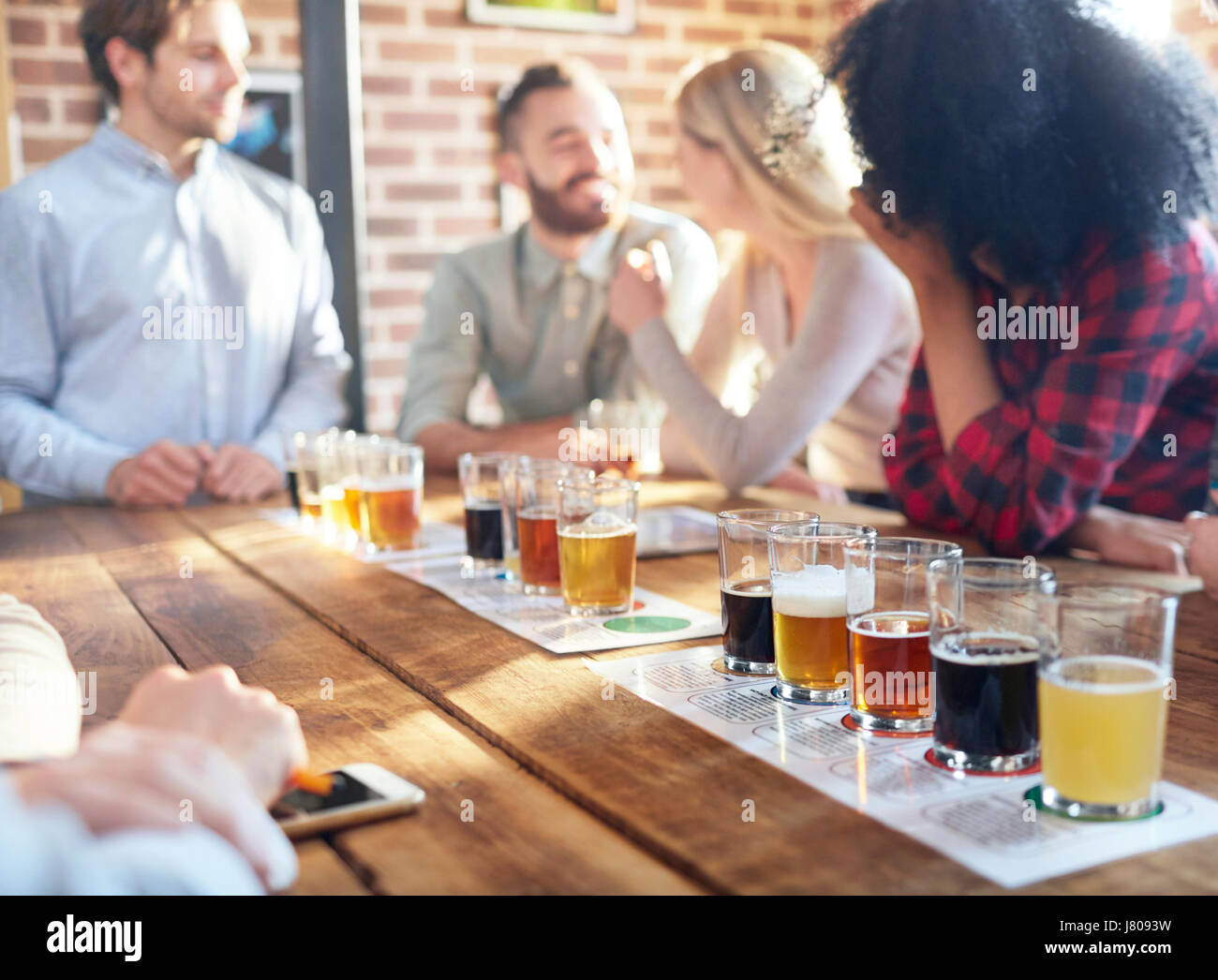 Gli amici la degustazione della birra campioni alla fabbrica di birra Foto Stock