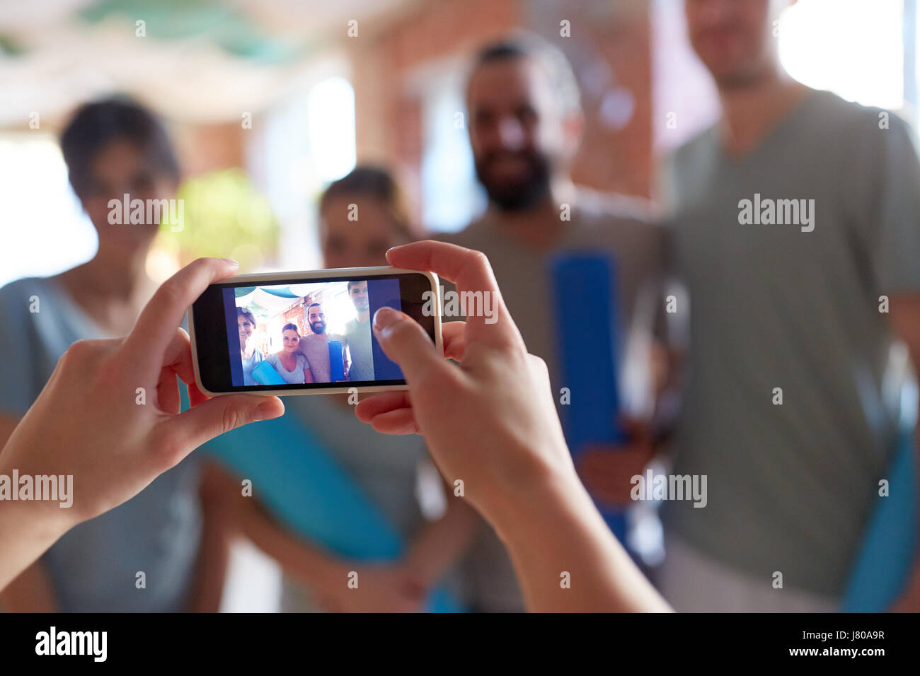 Foto di persone in studio di yoga sullo smartphone Foto Stock