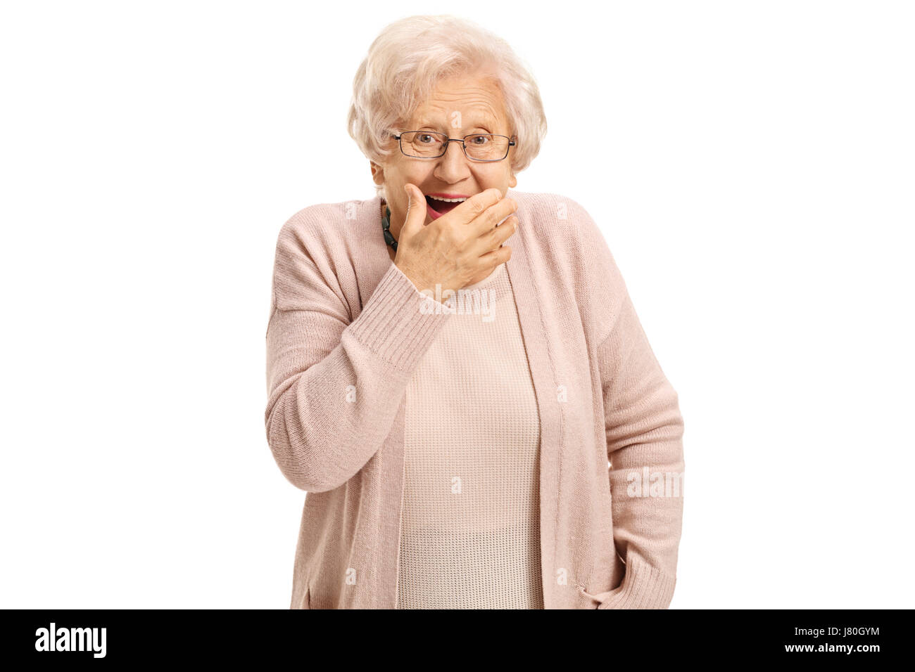 Sorpreso donna matura tenendo la sua mano contro la sua bocca e guardando la telecamera isolata su sfondo bianco Foto Stock