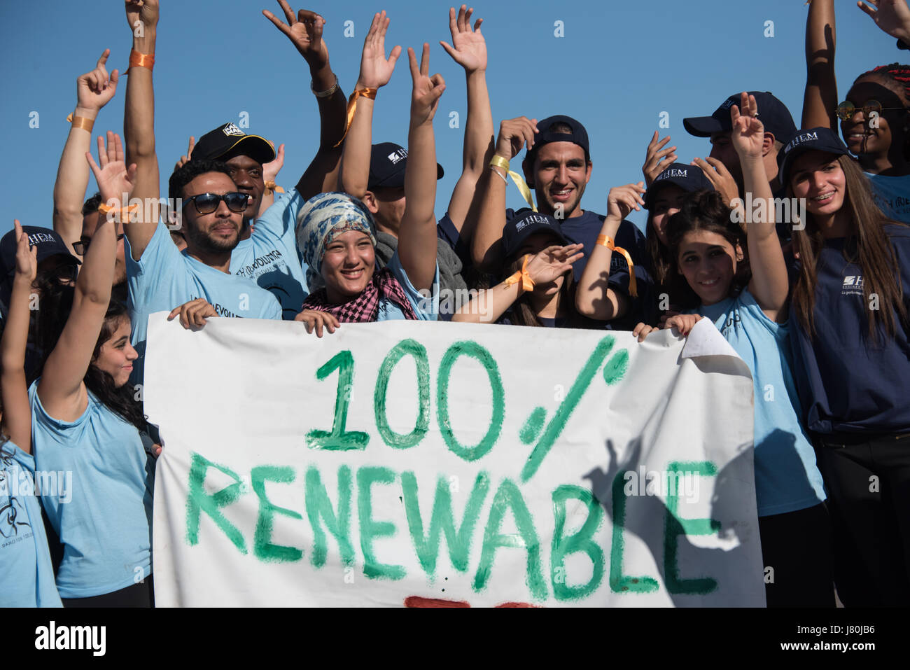 Giovani attivisti al COP22 conferenza ONU sul clima di tenere un segno a leggere '100%' rinnovabile a una dimostrazione in Piazza Jemaa El Fnaa, il mercato centrale plaza a Marrakech, Marocco, 10 novembre 2016. Foto Stock