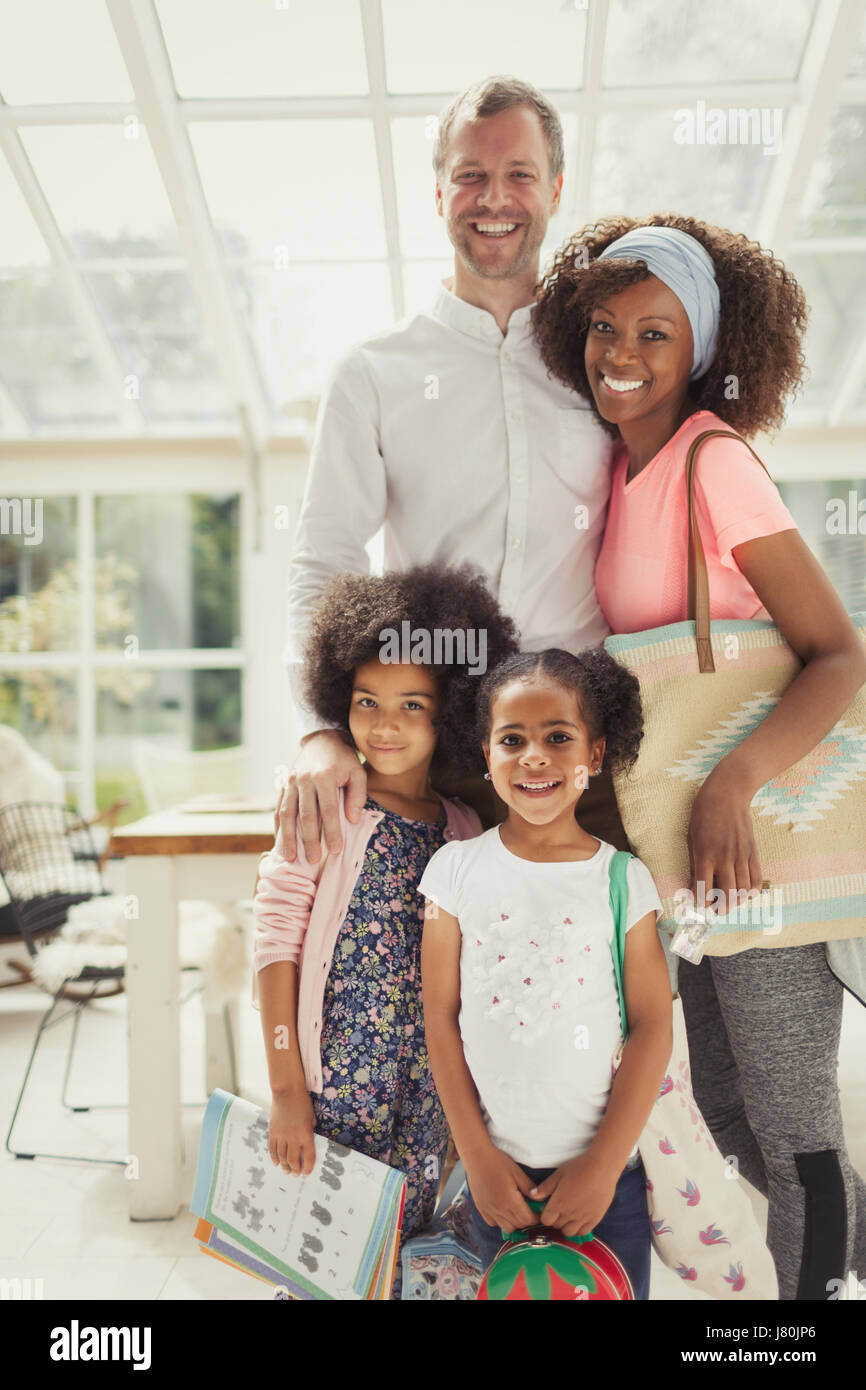 Ritratto sorridente multi-etnico famiglia giovani pronti a lasciare la casa Foto Stock