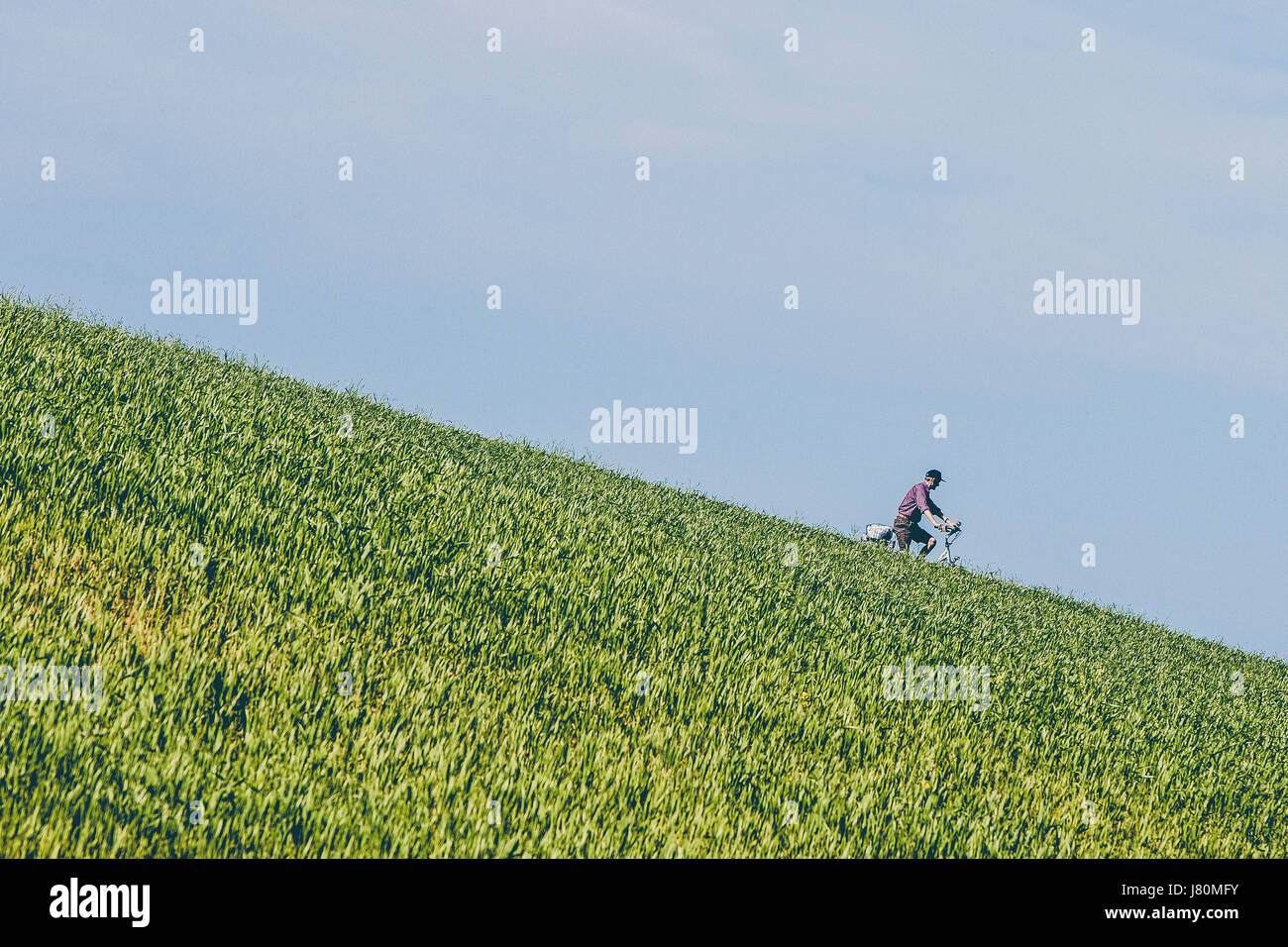 Un uomo spinge la sua bike downhill presso la costa in Schleswig-Holstein, Germania Foto Stock