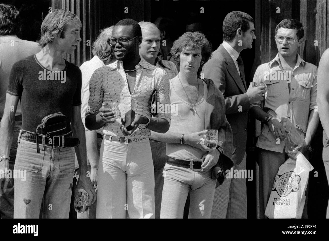 Pantaloni in jeans molto stretti alla moda britannica degli anni '1970. Scena gay Kings Road Chelsea. Il Markham Arms era un noto pub gay e luogo d'incontro al 138 di King's Road, Londra, Inghilterra, 1975 HOMER SYKES Foto Stock