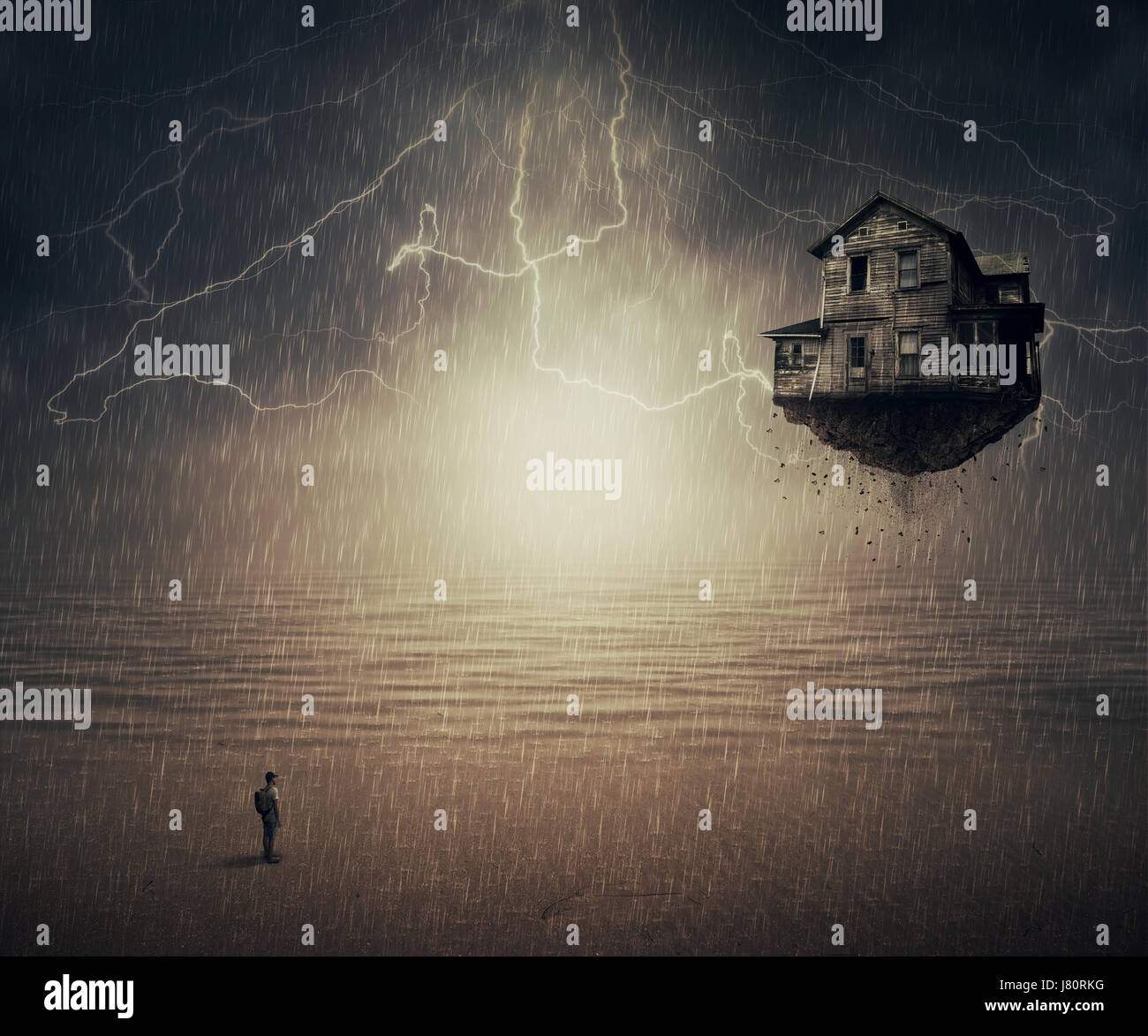 Backround surreale di un uomo in piedi sotto la pioggia, di fronte a una casa di volo strappato dal suolo, vicino all'oceano. Sesto Senso concetto. Foto Stock